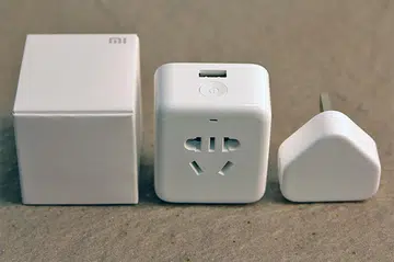 The Mi Plug (middle) beside the box it comes in and a regular iPhone USB power adapter.