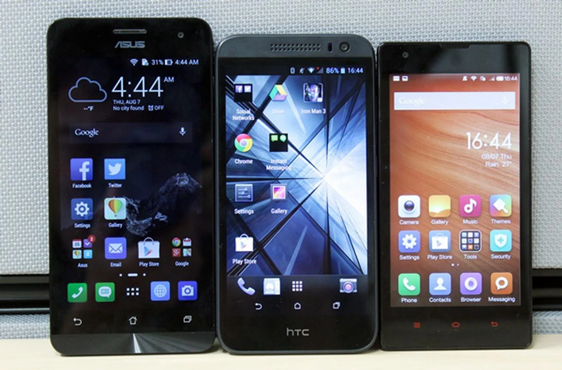 The front-facing shot of the three phones. <br> Left to right: ASUS ZenFone 5, HTC Desire 616 and Xiaomi Redmi 1S.