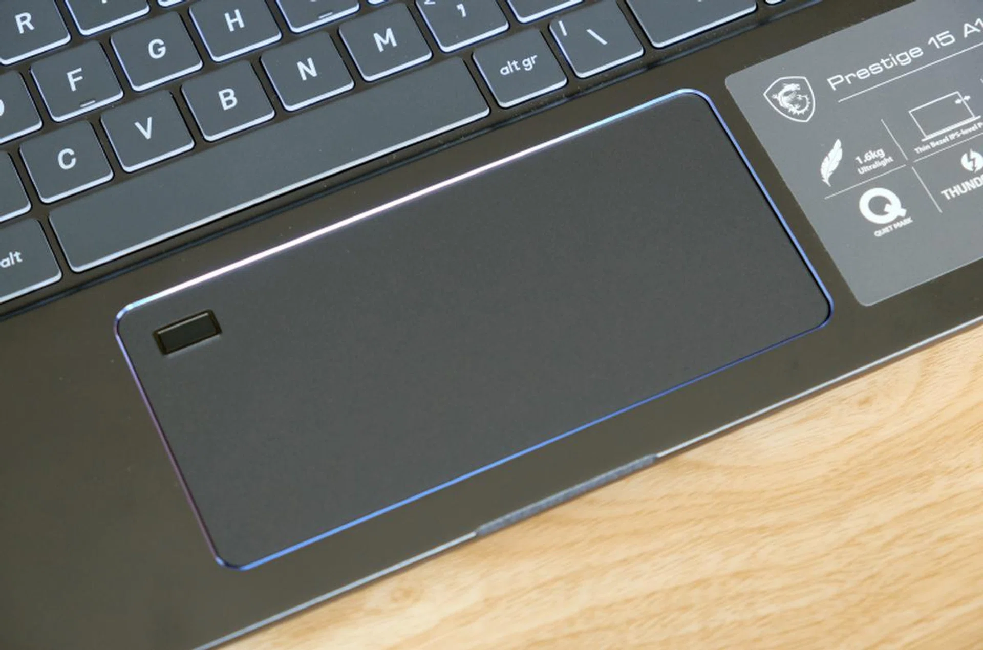 The trackpad is wide but narrow from top to bottom. Note the integrated fingerprint scanner in the top left corner.