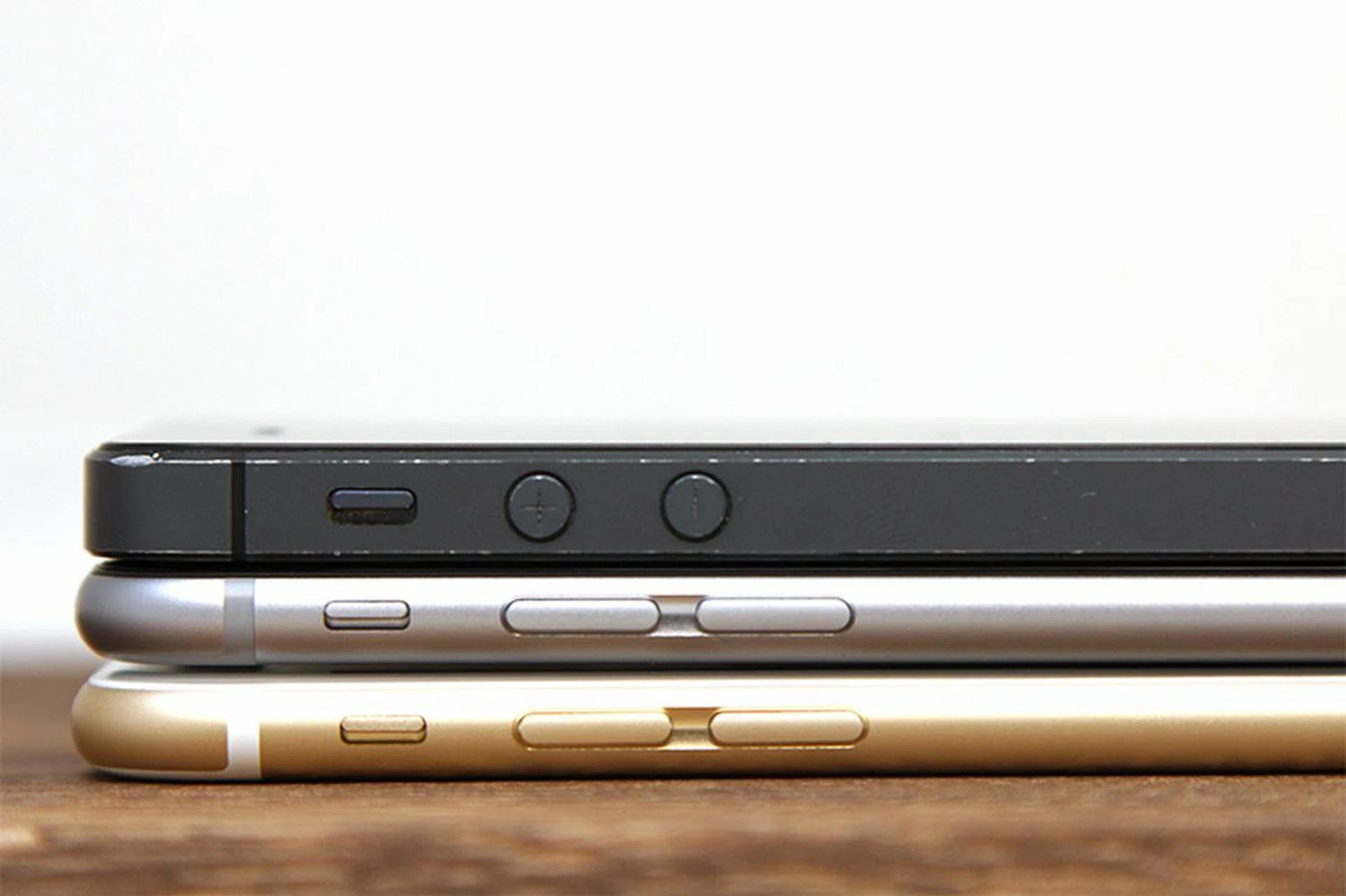 A battered iPhone 5 on top of an iPhone 6 and 6 Plus.