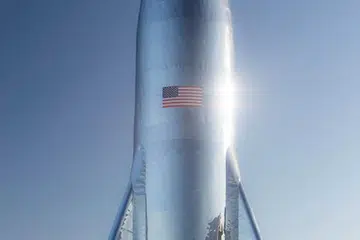 A gleaming Starship prototype stands at a SpaceX facility in Boca Chica Village, Texas. 