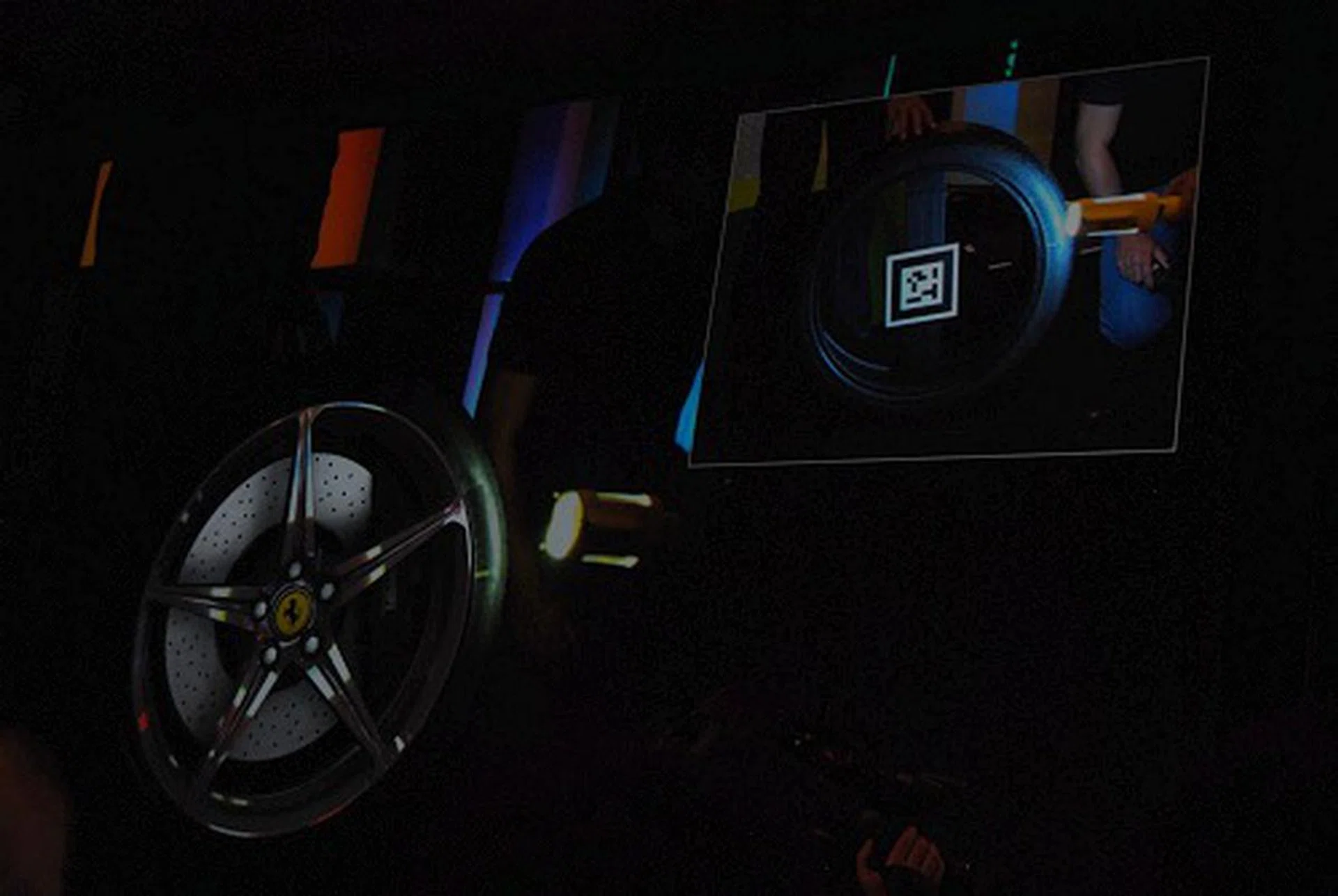 And here we see on screen what the computer is rendering in real time with the rims accurately lit while the inset shows the actual video feed of duo with the empty tire.