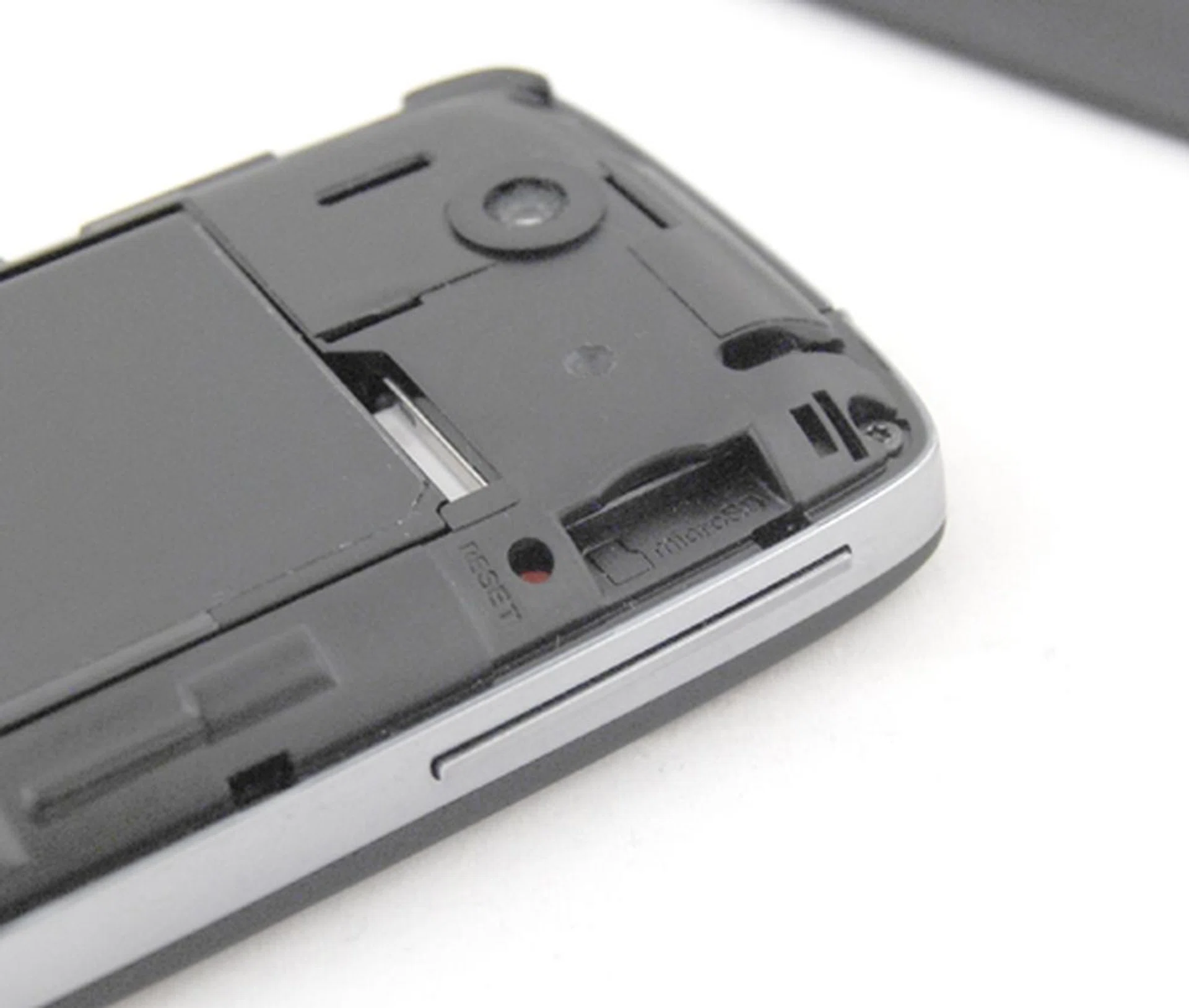 The soft reset button is located below the battery cover, which makes it not as easily accessible as its earlier siblings. As usual, the SIM card slot is located below the battery, whilst the microSD card is slightly more accessible next to the Reset button.