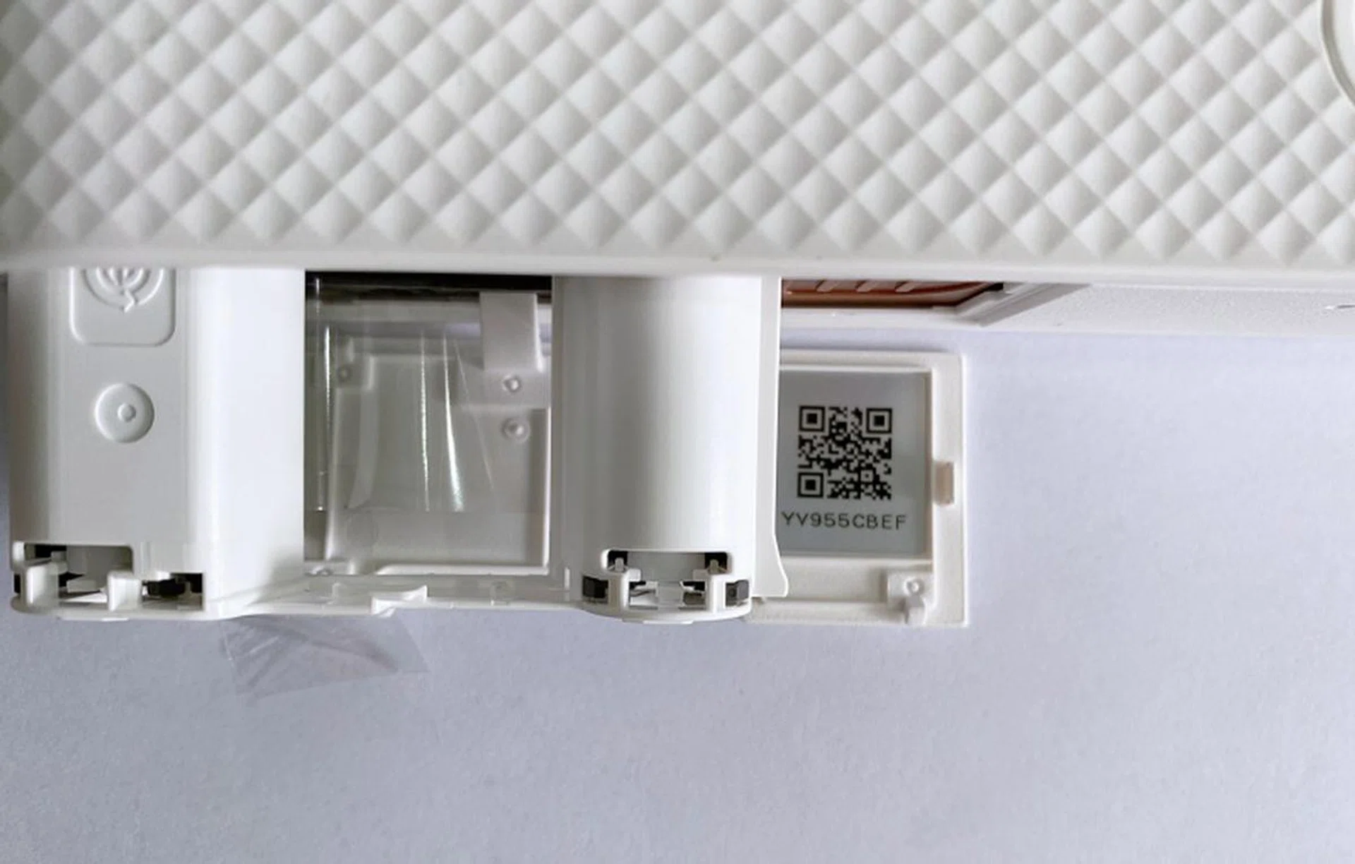 The QR code is on the flap that opens to insert the dye-sub cassette, which will lead you to download and install the required app on your phone.