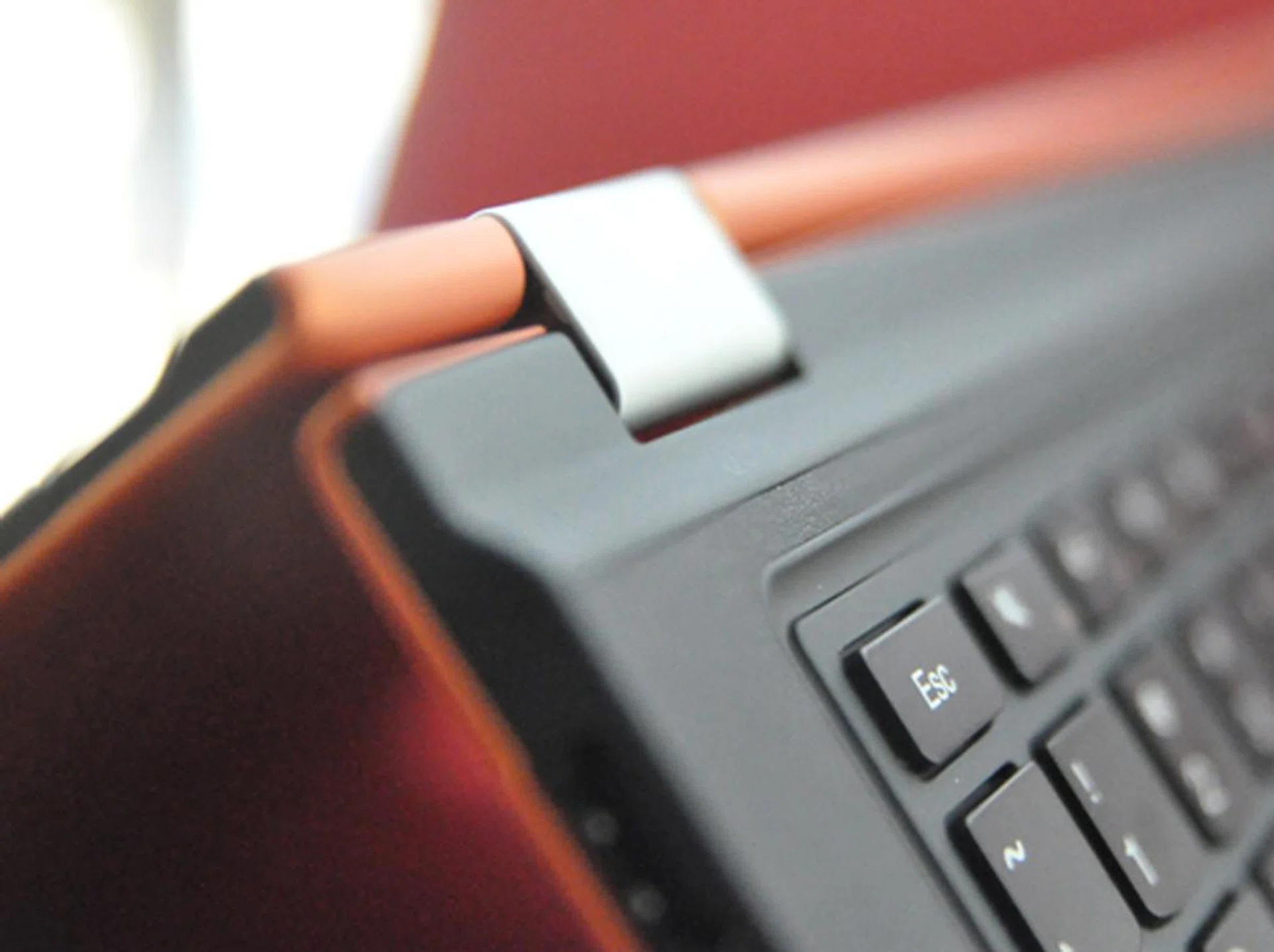 There is a slight indentation that allows the screen to easily rotate without being blocked. Both ends of the hinge can also rotate freely with no obstruction, which is why both sides can flip open into "tablet" mode. 