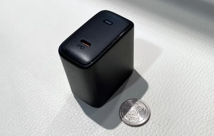 This is Aukey's 100W Omnia charger next to a US quarter.