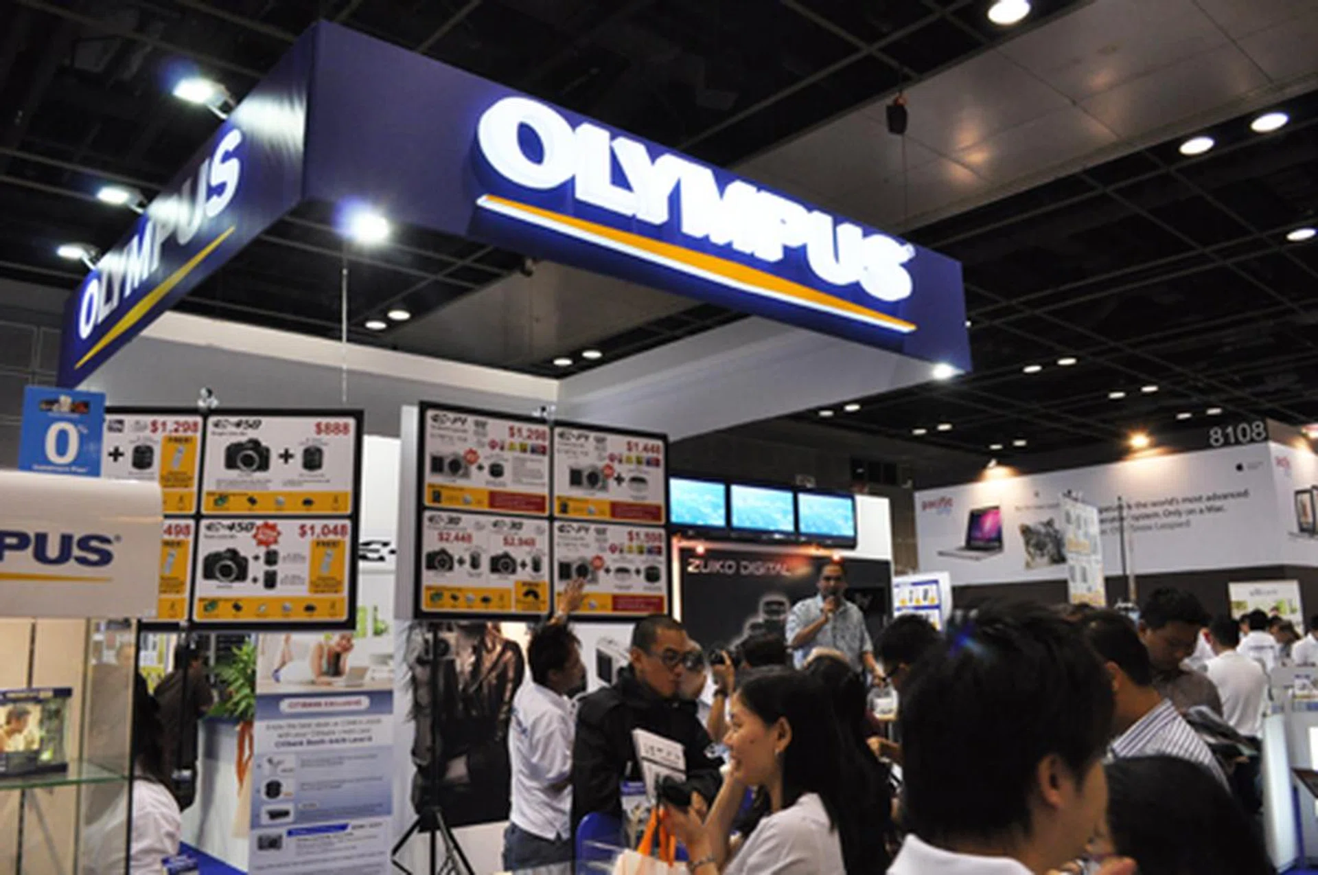 The Olympus booth is on the 4th floor, near the central entrance.