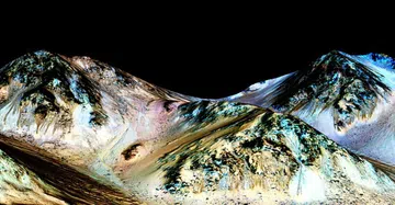 These dark, narrow, 100-metre streaks called recurring slope lineae flowing downhill on Mars are inferred to have been formed by contemporary flowing water.<br>
Source: Mars Reconnaissance Orbiter/University of Arizona/JPL/NASA