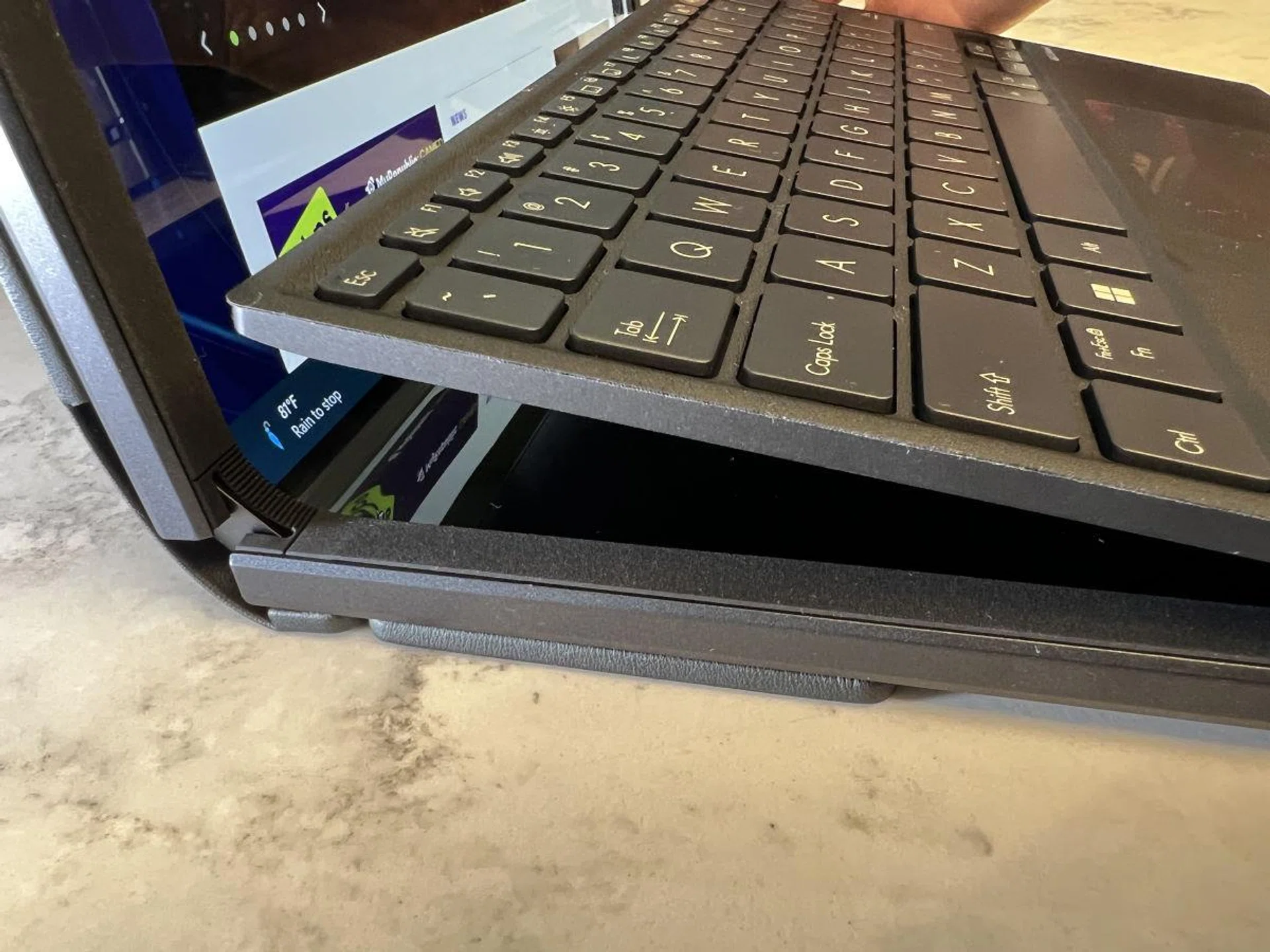 The magnetic Bluetooth keyboard snaps onto the frame of the notebook which will deactivate the bottom half of the screen.