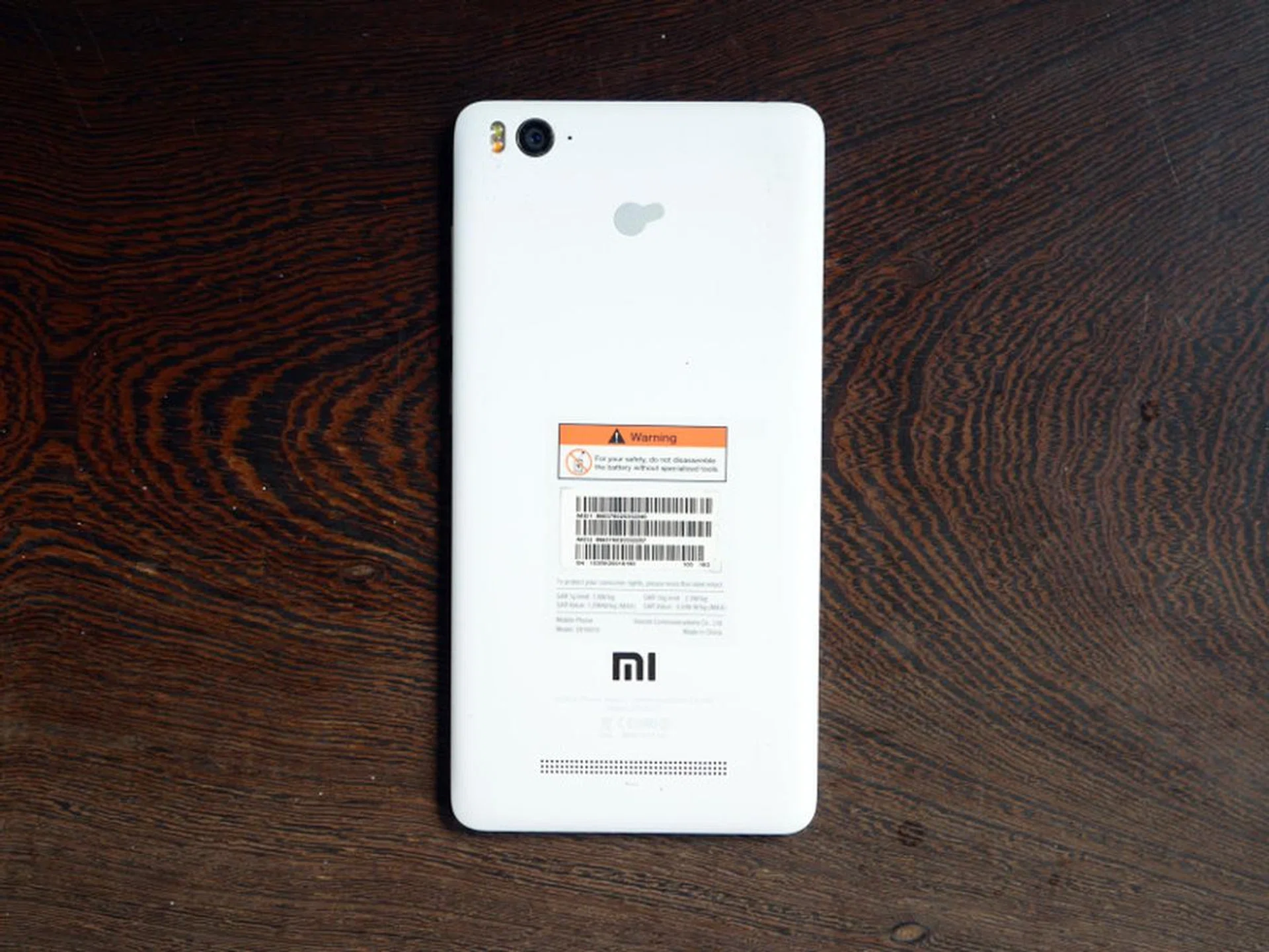 The speaker grille is located on the rear of the phone, right at the bottom.