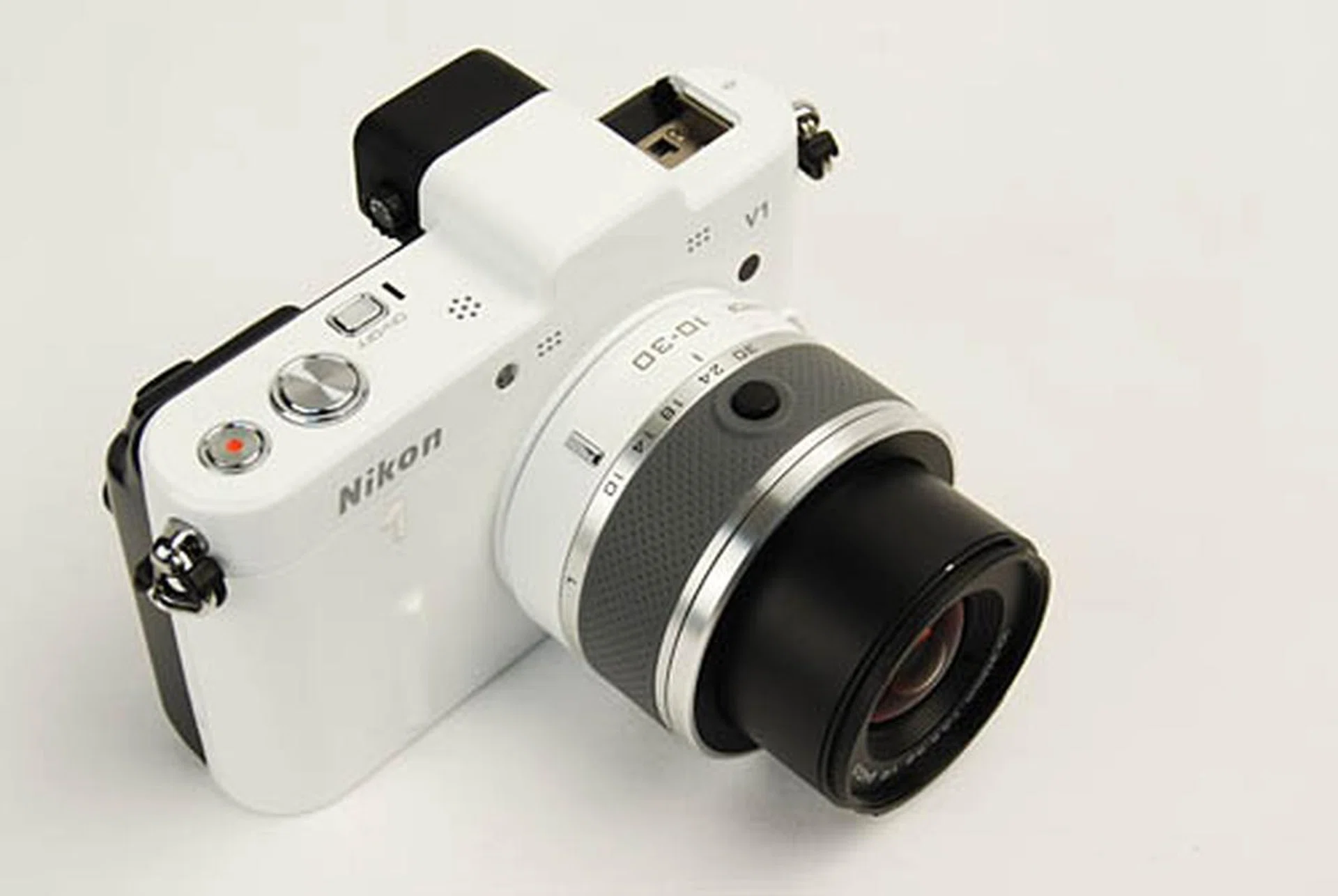 Unlike Olympus's MFT lenses which have a sliding lock, the Nikon 1's lenses have a button lock which is easier to unlock. Unlocking the lens also conveniently powers on the camera at the same time.