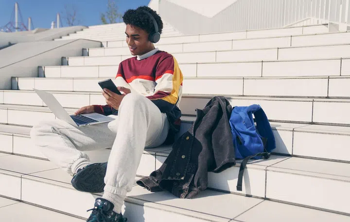 Male model pretending to a student uses Multipoint to connect to multiple source devices.