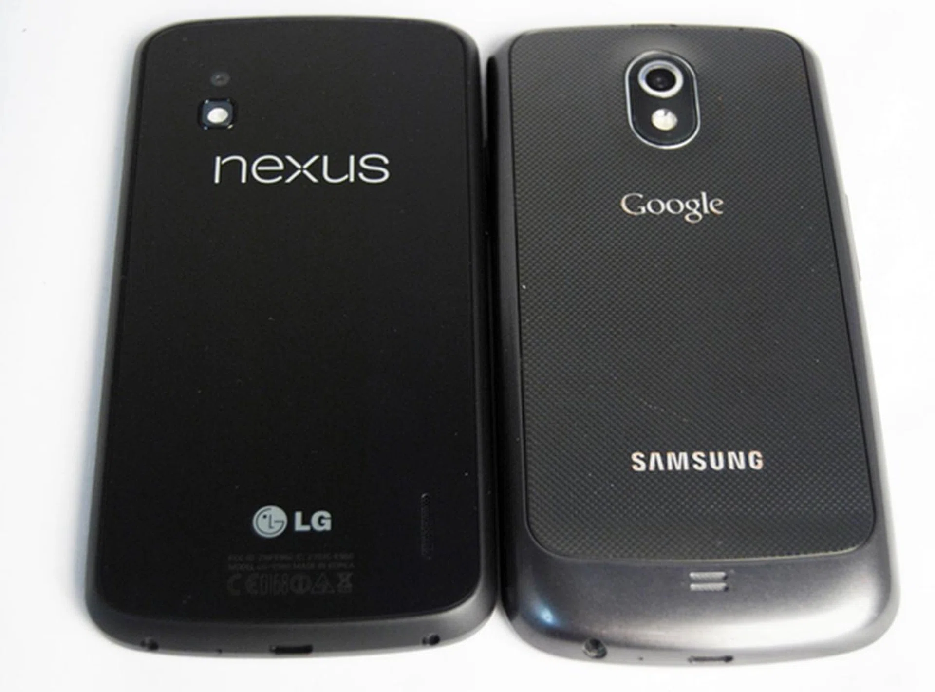 Bid farewell to the hyper-skin backing of the battery cover of the Samsung Galaxy Nexus (right). It is replaced with a solid and smooth glass back panel on the LG Nexus 4 (left).