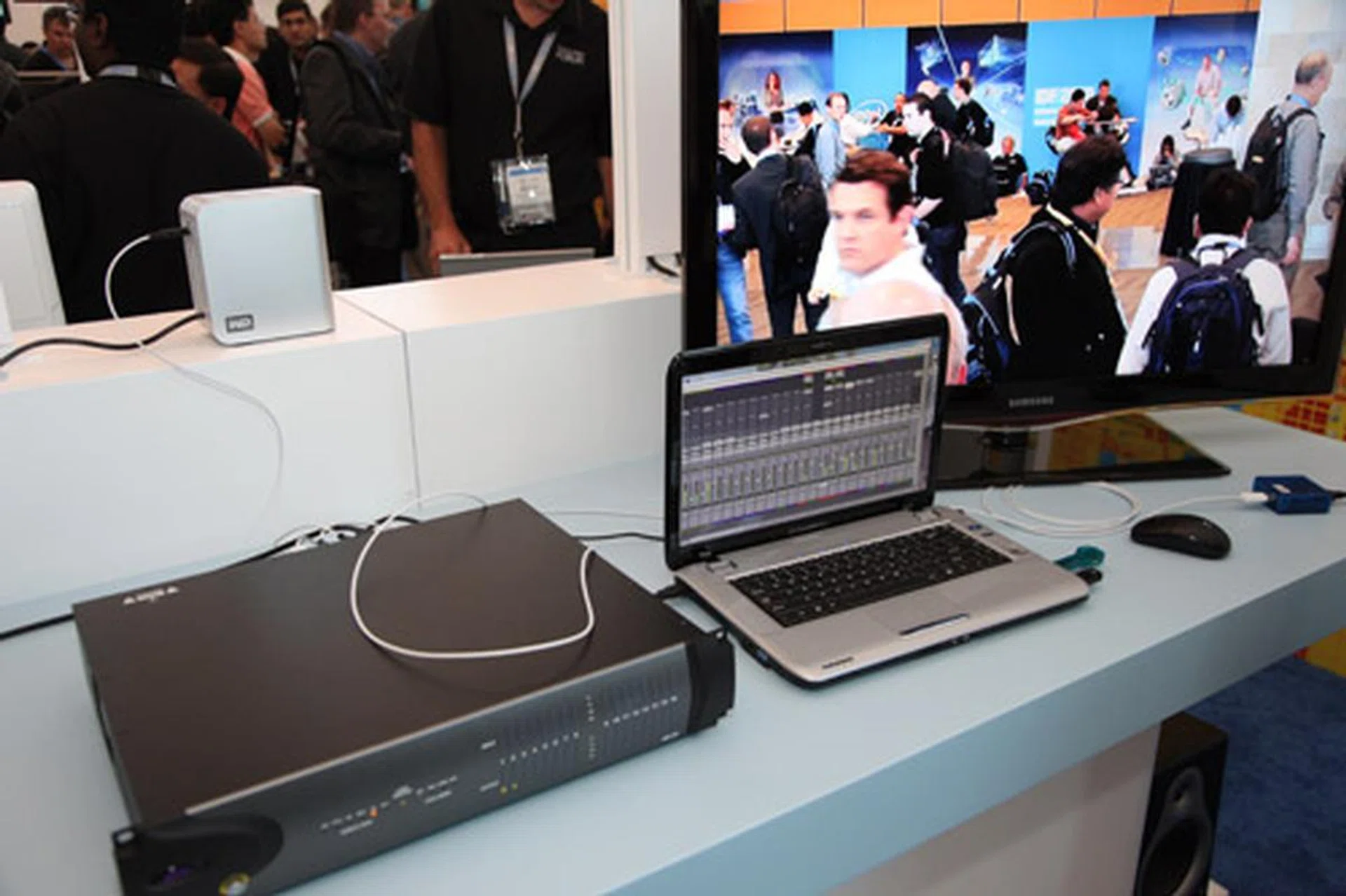 A demonstration showing how devices in a video editing system are connected using Light Peak. In this demonstration, a laptop using Light Peak is connected to a video editing hardware box while the external storage box, TV and video camera are connected to the video editing device using the same Light Peak bus.