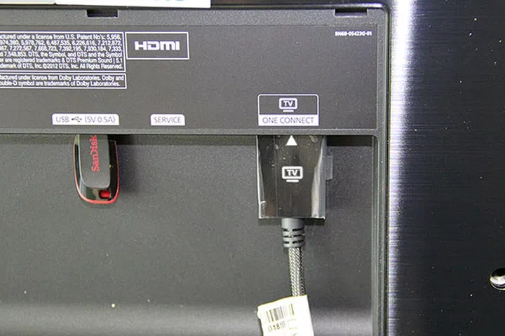 The One Connect cable goes to the back of the TV, where the port is located under a compartment door.