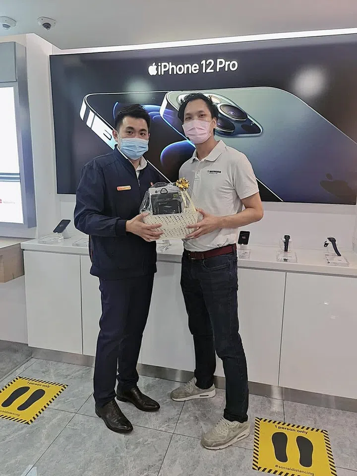 Mr Seo Jialiang, Jerald (right), lucky winner of the hamper with his purchased iPhone 12 mini. Image credit: M1.