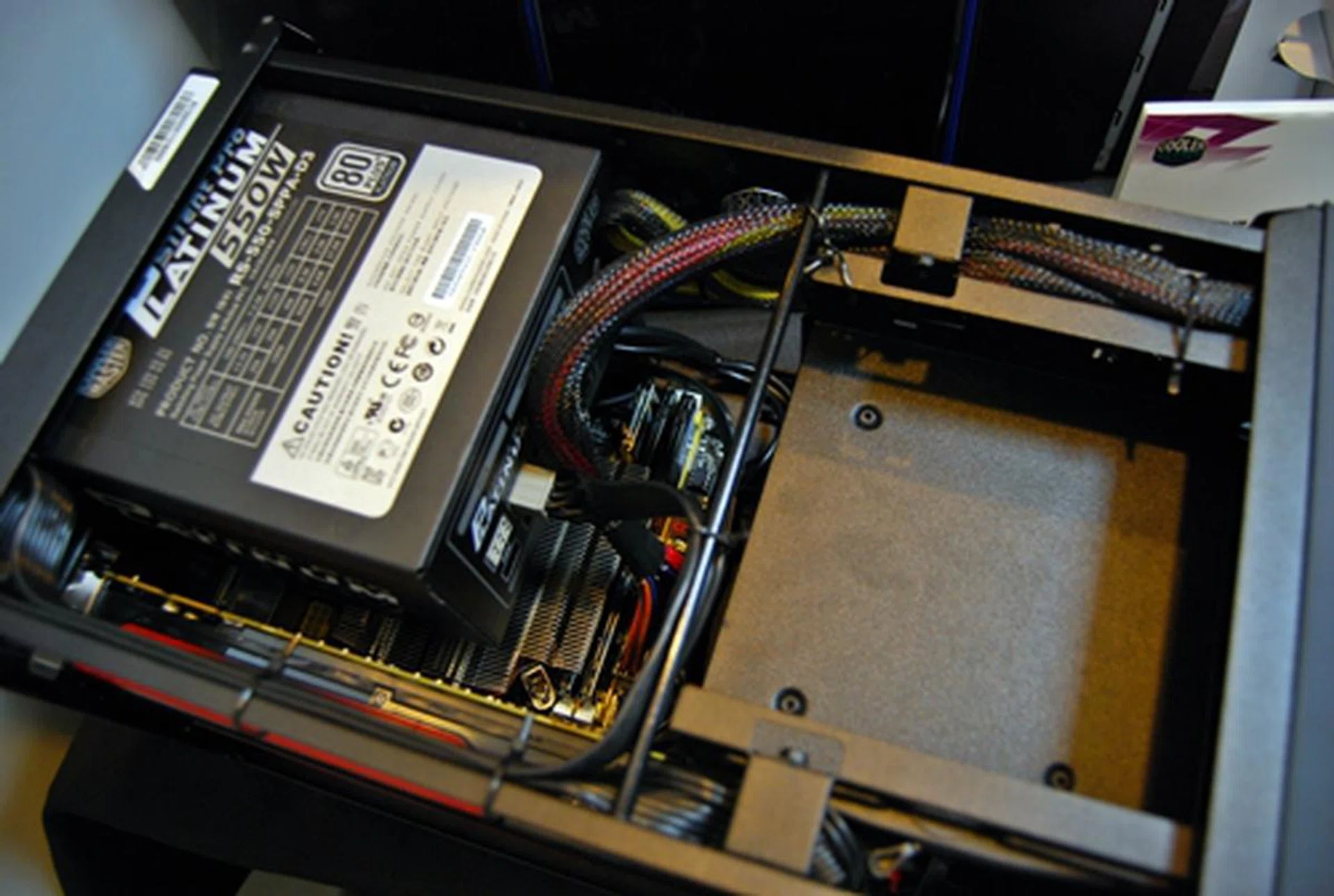 With its top removed, we see an ATX PSU installed that is the Cooler Master Elite Pro Platinum 550W (rated 80 Plus Platinum).