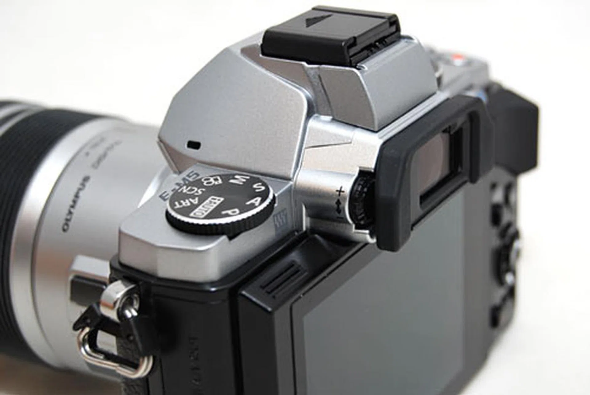 The hump on top of the E-M5 houses the electronic viewfinder, hot shoe adapter and accessory port. The camera does not have a built-in flash.