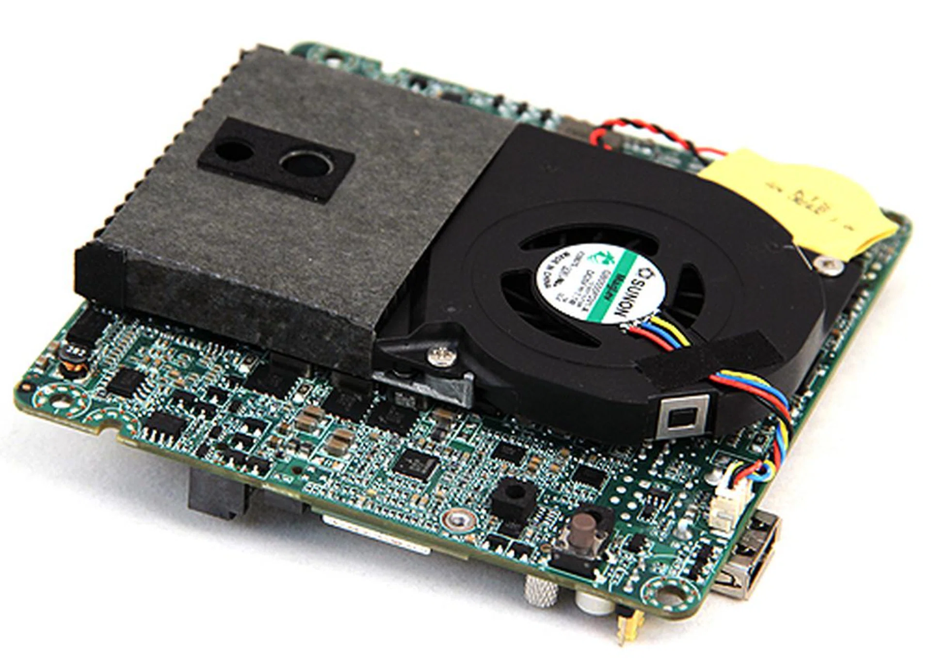 Flipping the motherboard over, we can see the blower type cooler which conceals the soldered on Core i3-3217U processor. The cooler is very quiet.