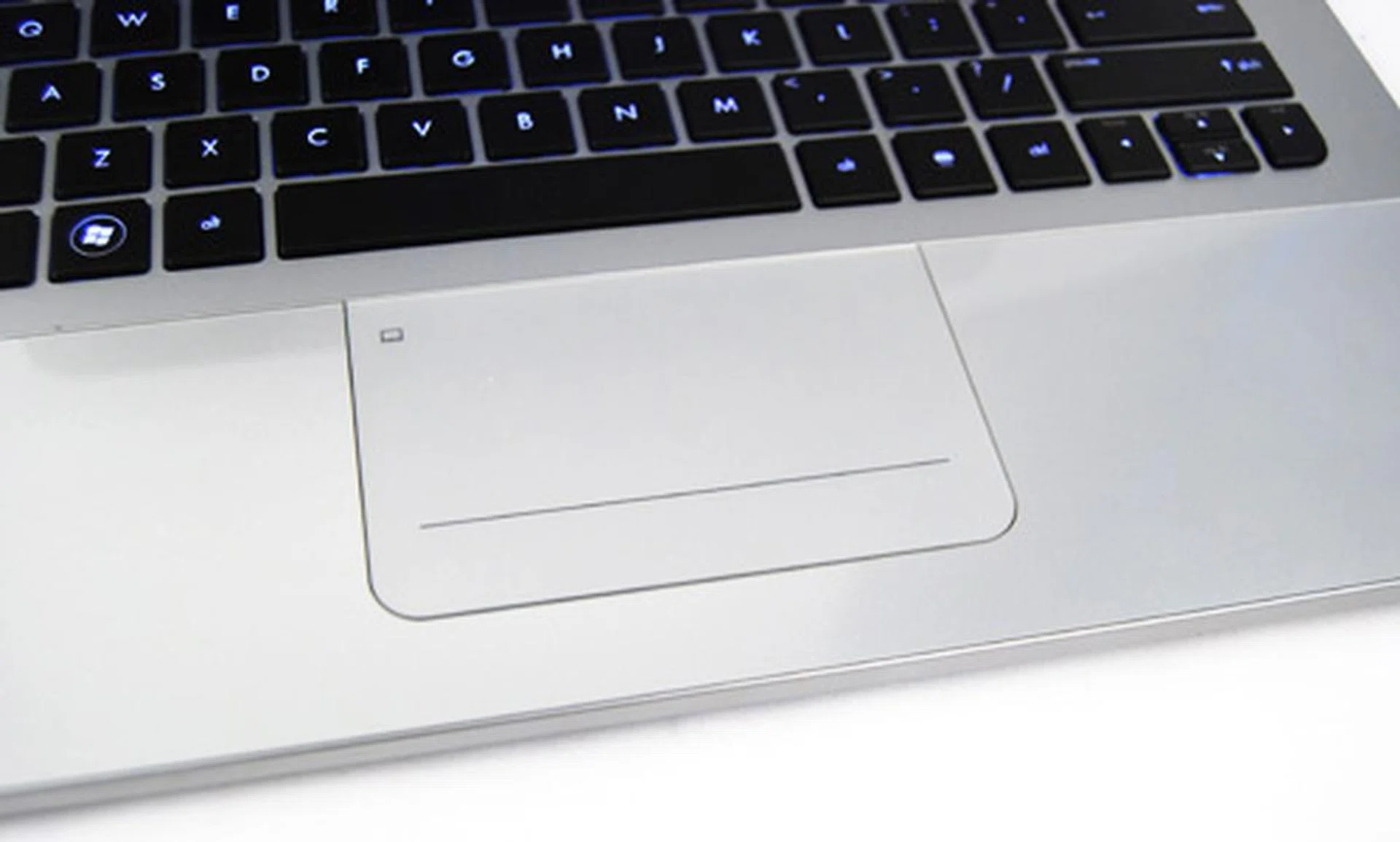 The track pad is flush with the glass wrist rest, making it slightly elevated from the keyboard.