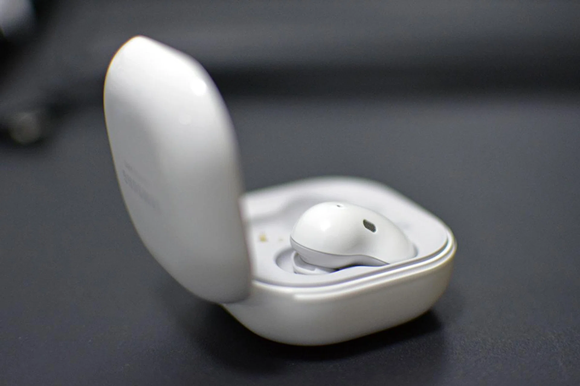 The earbuds rest in their case at an angle, making them easy to pull out.