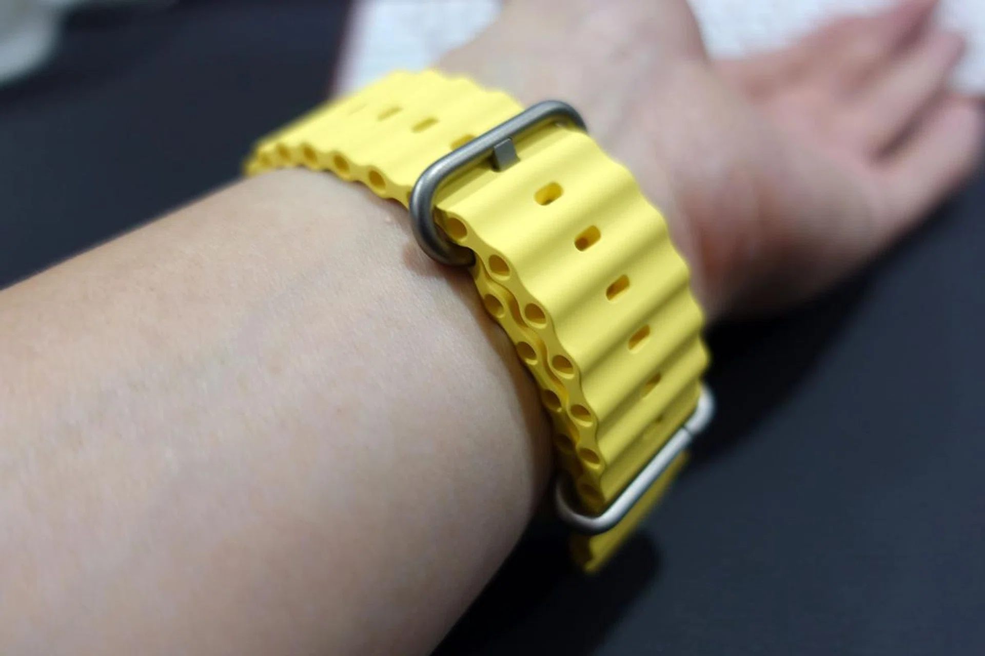 The Ocean Band is moulded from fluoroelastomer rubber. It has a titanium buckle and a spring‑loaded titanium adjustable loop that secures through the tubes for a hypersecure fit, even during high-speed water sports. An attachable strap extension lets you wear it over a thick wetsuit.