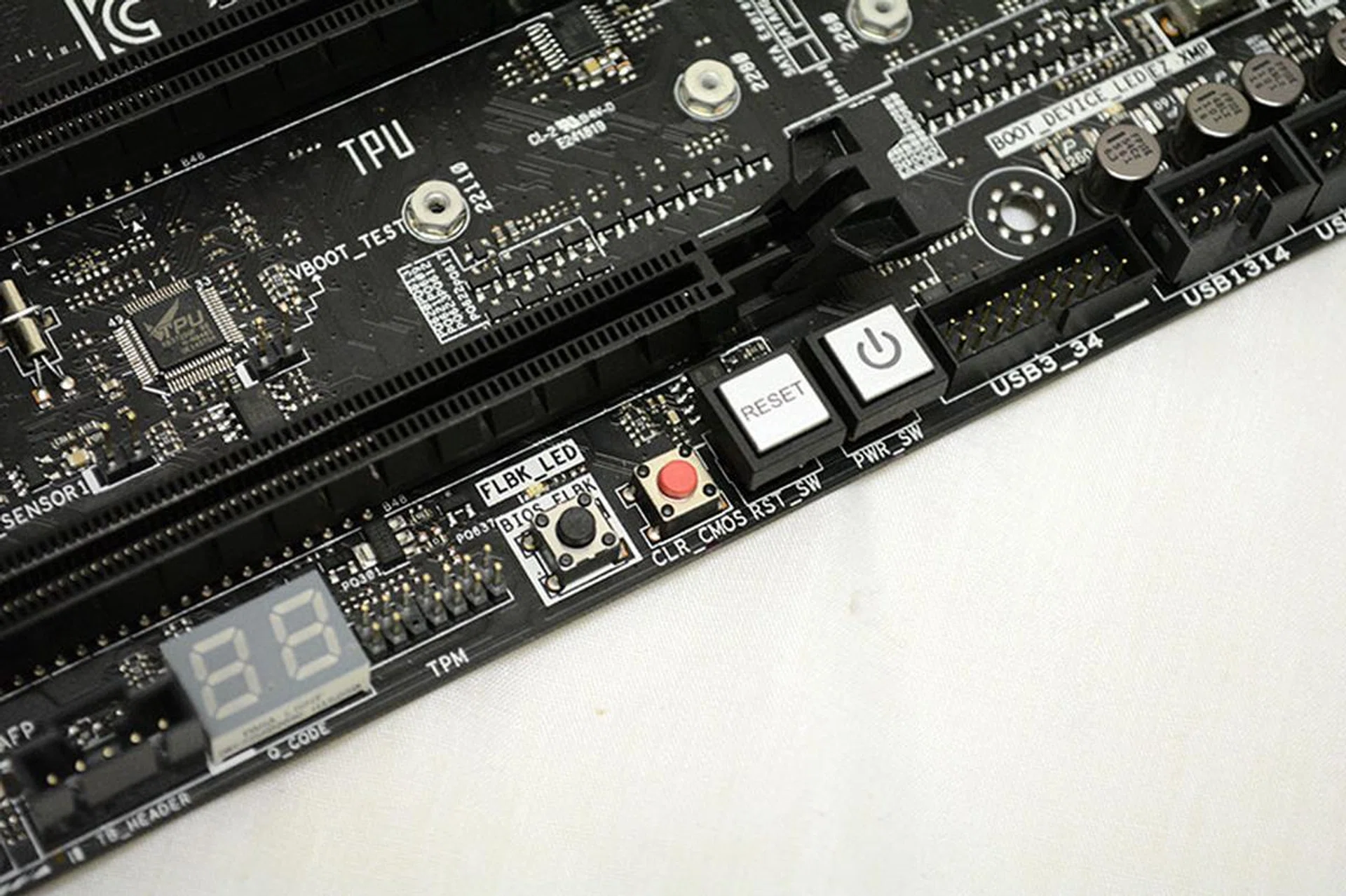 The power and reset buttons, the debug LED display, clear CMOS button, and USB BIOS flashback button are located at the bottom.