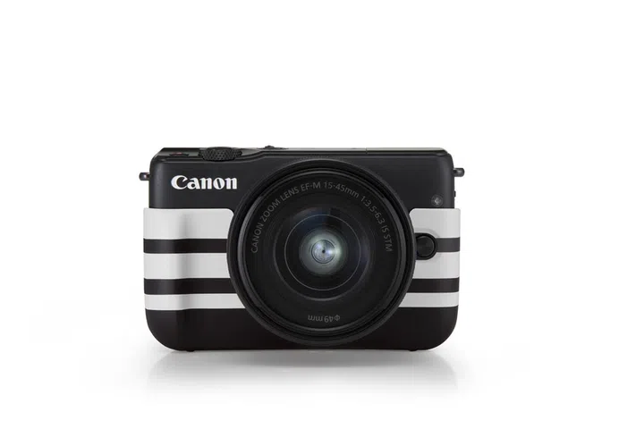 A black Canon EOS M10 with limited edition jacket in border pattern,