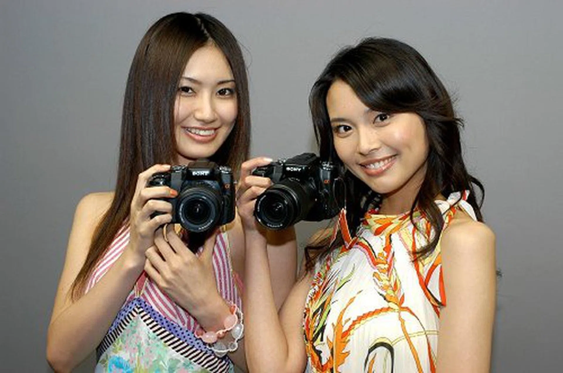 Models proudly showcasing the Sony Alpha A100. Look carefully and you could probably make out the size of the camera from their handling.