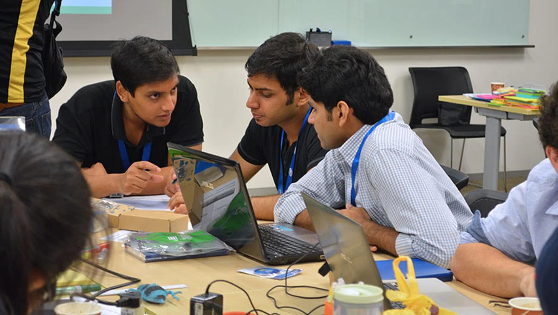 Team GREEN deep in discussion. They aim to create gamified smart homes to encourage users to conserve energy.