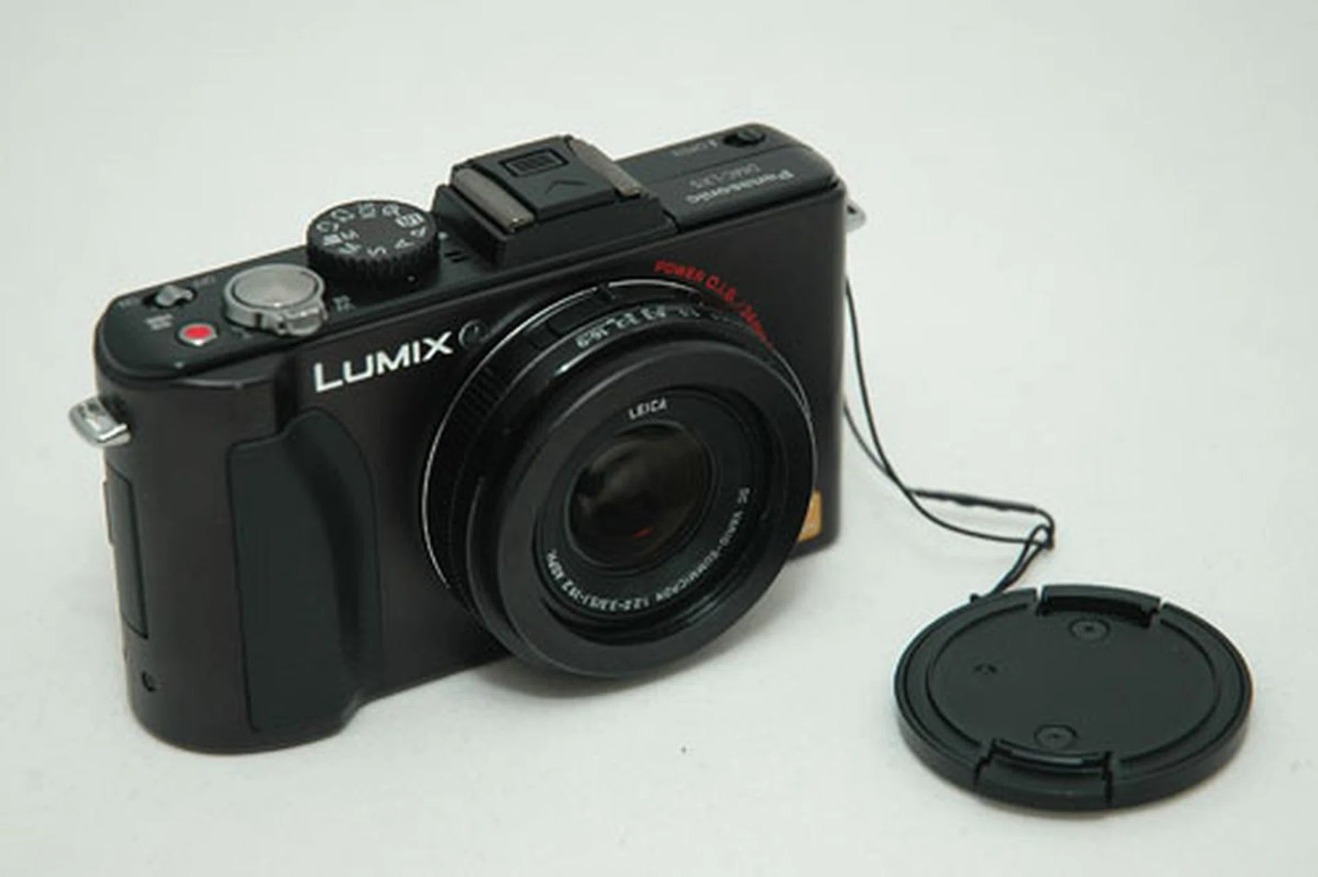 Bad news; the lens cover is still manual.