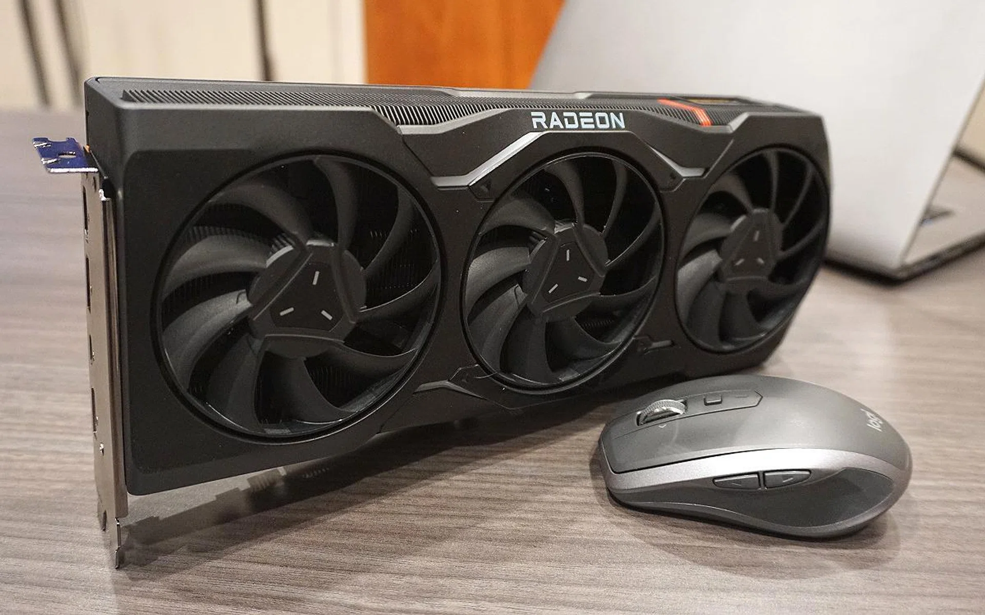 A Logitech MX Anywhere 2S is placed next to the card for size, which clearly indicates that the Radeon RX 7900 XTX is quite reasonably sized and not anywhere as large as the NVIDIA GeForce RTX 40 series. However, the Radeon RX 7900 XTX is still a very hefty product. Don't let the plain looks fool you.