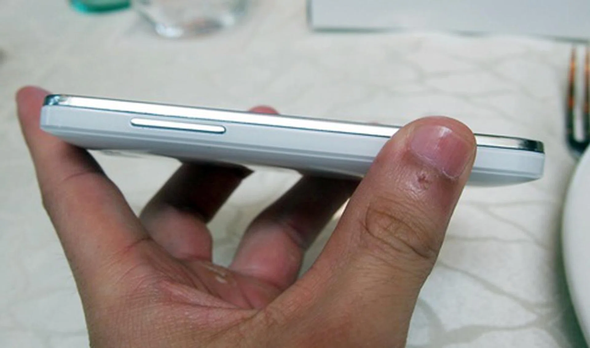 You can find a metal button strip on the left side of the Huawei Honor. Due to the difference in materials used (plastic body with metallic button), you can easily feel for this volume button.