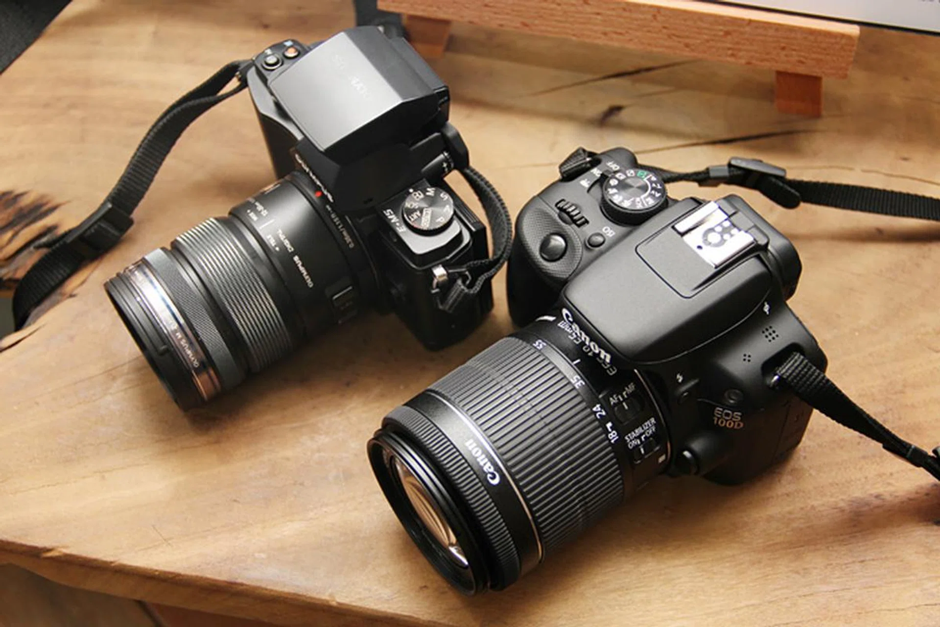 The Canon EOS 100D is small for a DSLR. While it's thicker than the mirrorless Olympus OM-D E-M5 camera, it's only slightly taller than the E-M5 with its flash attached and is lighter.
