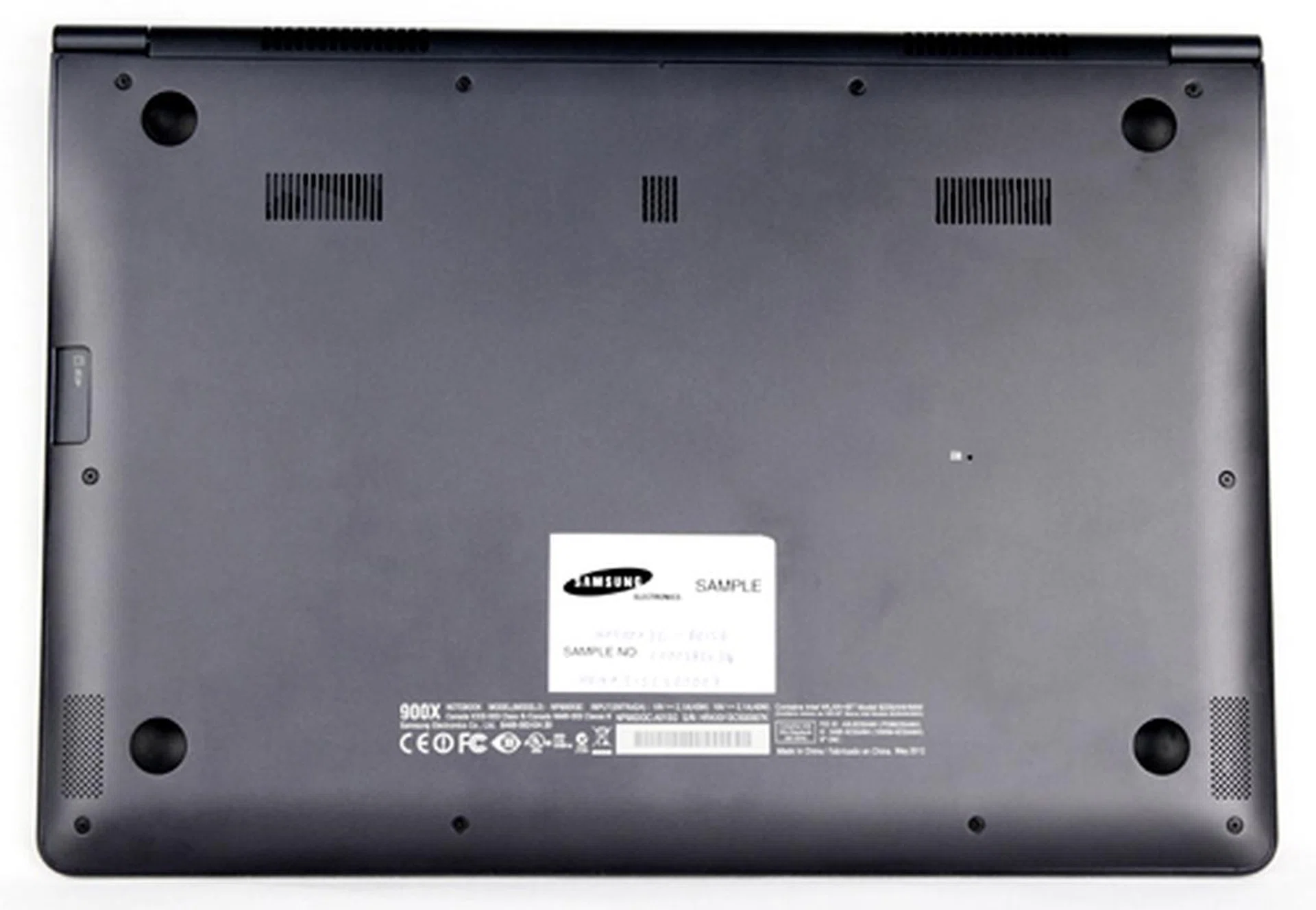 On the bottom left and right (which is actually closer to the front face of the machine), you will find the speakers located on the curved sides. On the left side, you can see the SD card slot, which has a protective cover when you're not using it. 