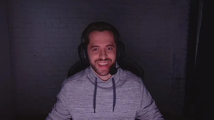 This Razer handout photo shows the Kiyo Pro's performance in a dark room, with the subject's face illuminated only by his monitor. (Image: Razer)