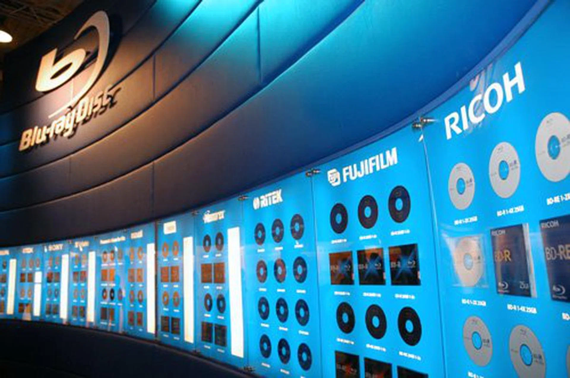 A wall lined up with Blu-ray recordable and re-recordable by the likes of Ricoh, Memorex, Fujifilm, Ritek, Verbatim, TDK and so on. Expect these brands of BD-R and BD-RE discs to invade our shores in abundance soon. In Europe, the 50GB BD-R (write-once) costs 35 Euro (about S$70) while the 50GB BD-RE (rewritable) costs 45 Euro (about S$90). TDK upped the ante further with the recent announcement that theyï¿½ve achieved a Blue-Laser Disc Technology supporting a 200GB capacity disc, which improves on their previous 100GB prototype disc technology.