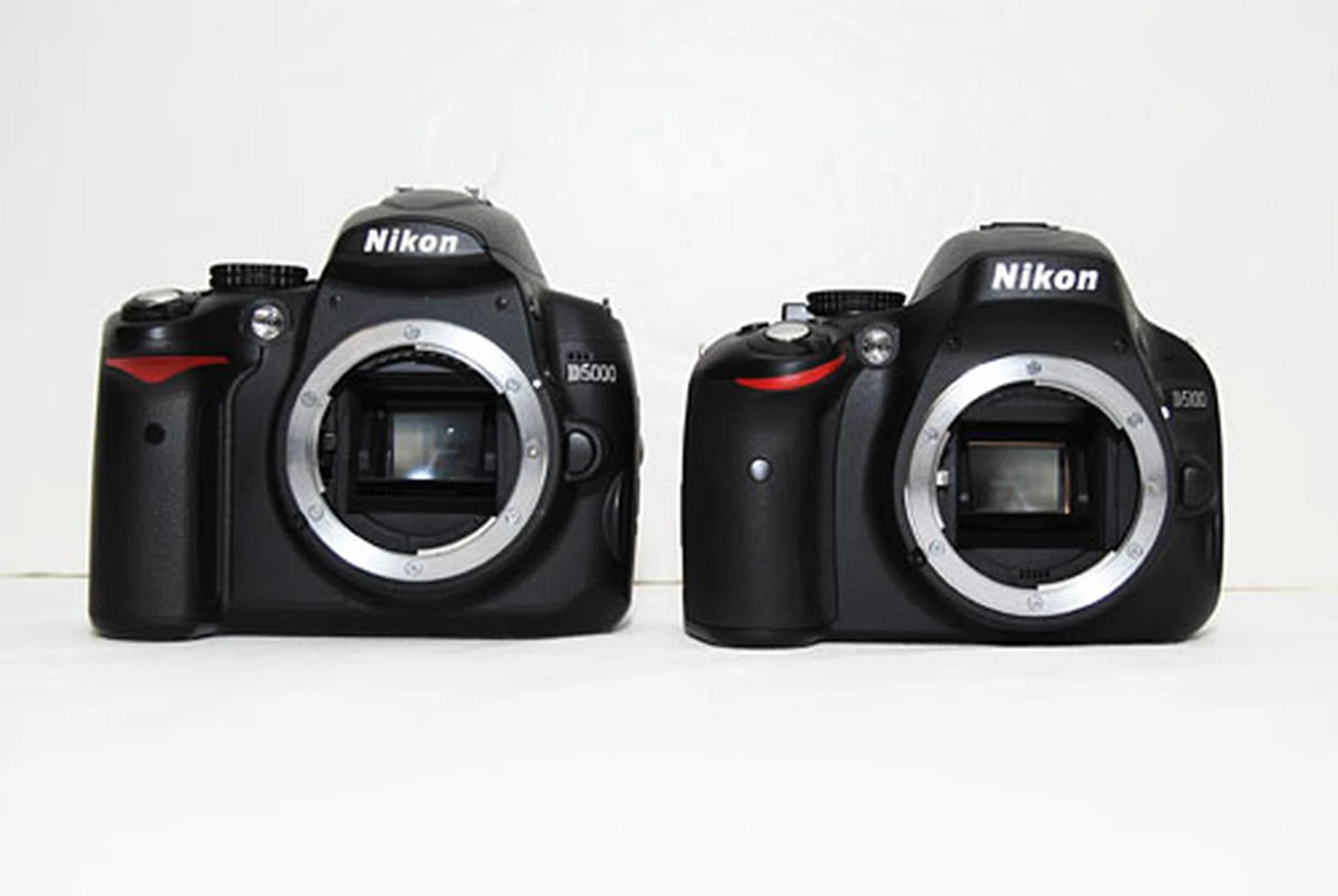 The D5100 is a noticeably shorter and curvier camera than the D5000. Can you guess which is which?