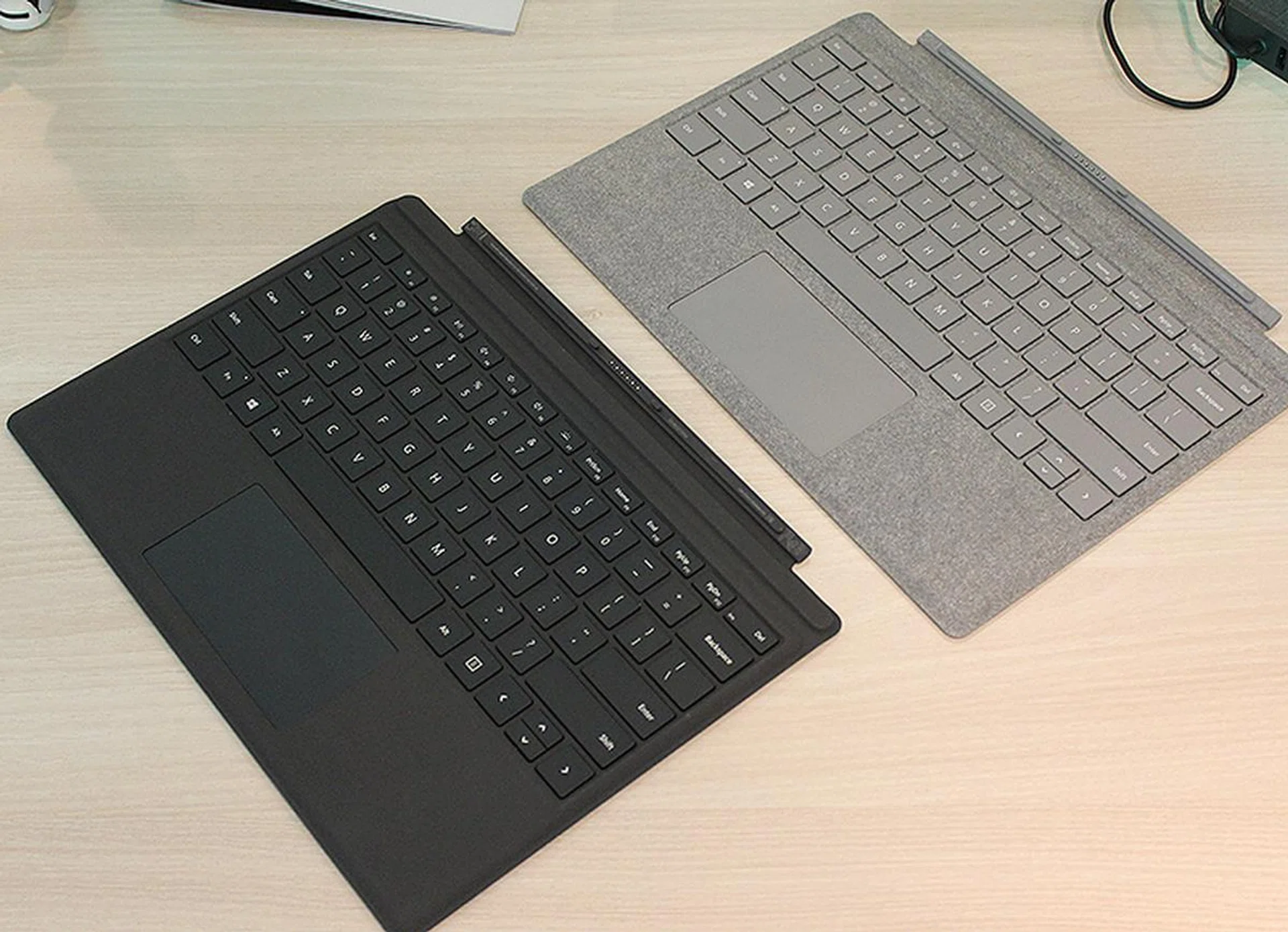 Surface Pro Signature Type Cover in Platinum to the right. Regular Surface Pro Type Cover in black to the left.