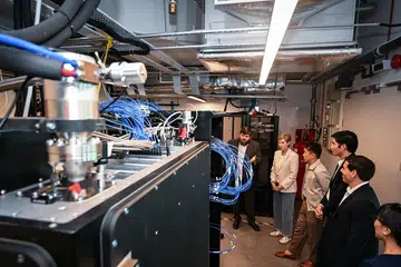 Image of Minister for Digital Development and Information Josephine Teo viewing Horizon Quantum’s new quantum computer, with company founder and chief executive Joe Fitzsimons