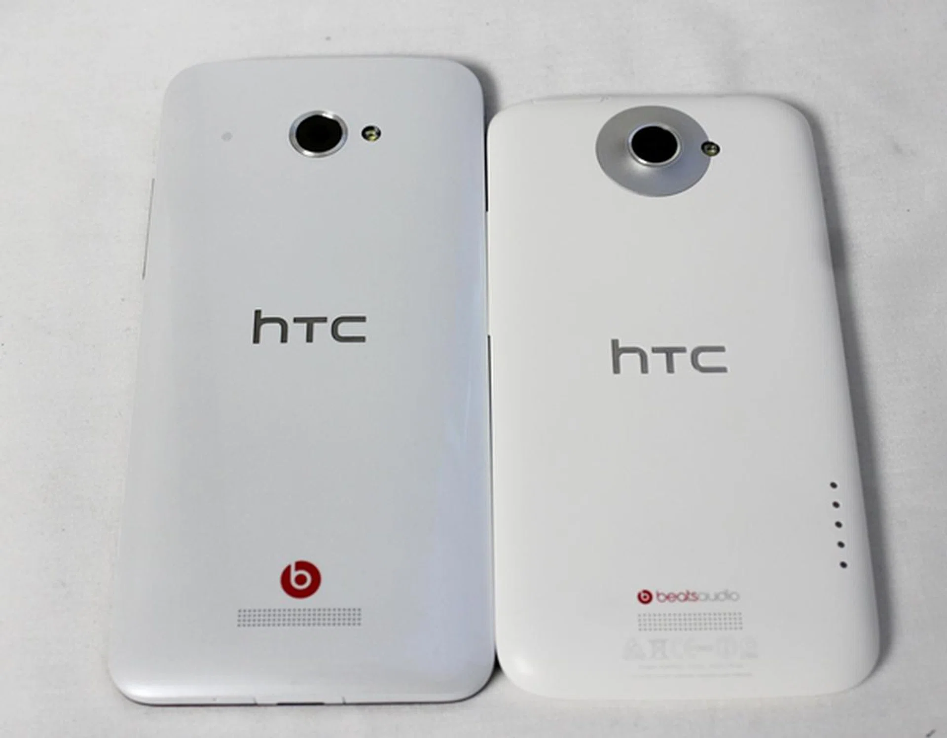 The 8-megapixel rear camera on the HTC Butterfly (left) remains flushed with the chassis, unlike the protruding rear camera on the HTC One X (right).