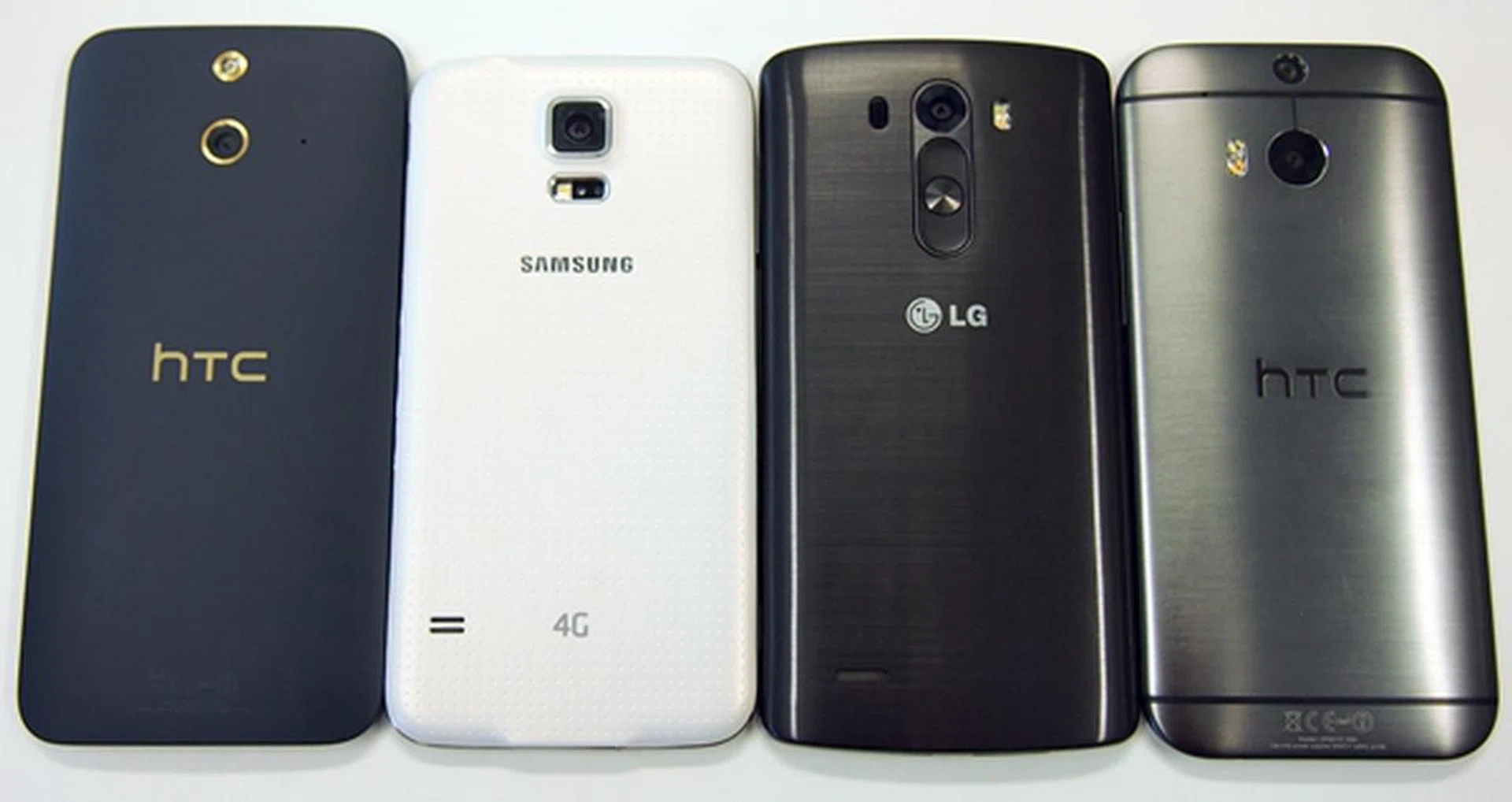The rear view of the phones. <br>From left to right: HTC One (E8), Samsung Galaxy S5, LG G3, HTC One (M8).