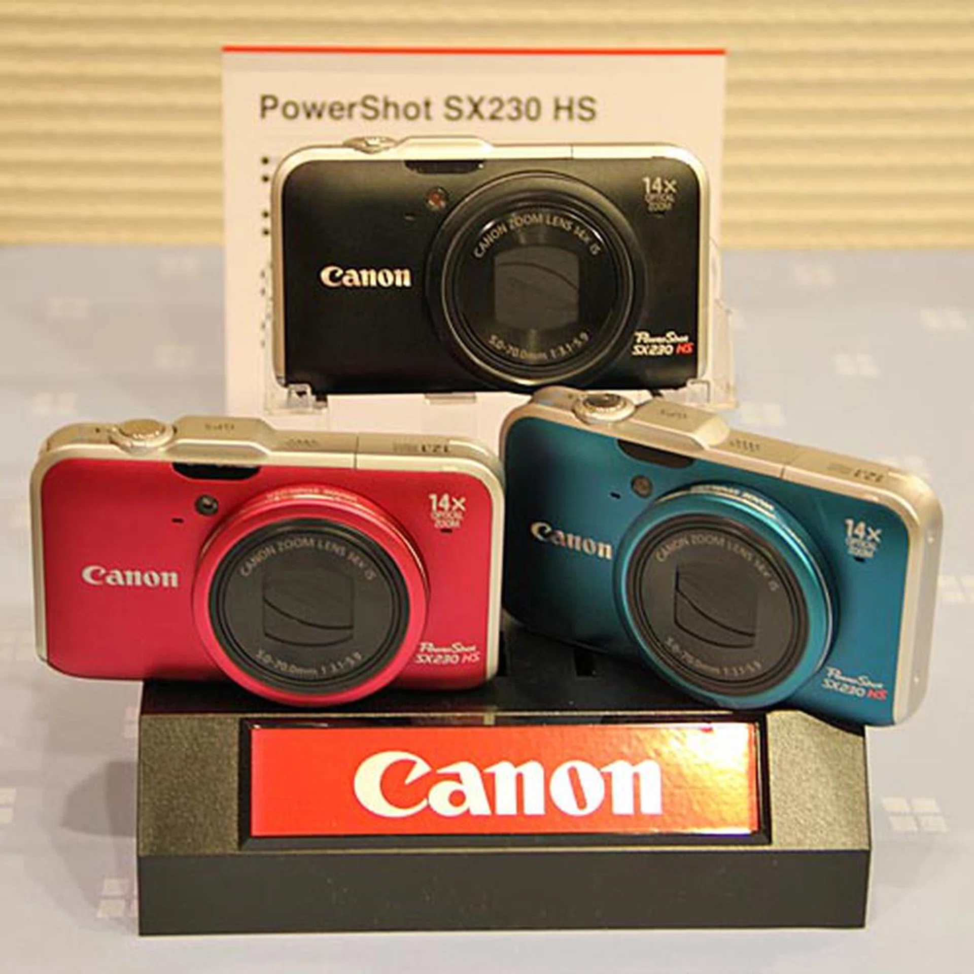 The 12.1-megapixel, Full HD movie recording-capable PowerShot SX230 HS comes with built-in GPS, 28 mm lens with 14x optical zoom (28 – 392 mm in 35 mm equivalent), Canon’s HS system, six creative filters, a Smart Auto mode that detects 32 different scenes, and the new Movie Digest feature. It’s available in blue, red and black.