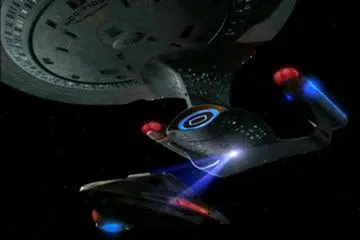 The Enterprise-D towing a broken down shuttle back to Earth shipyards using a tractor beam
