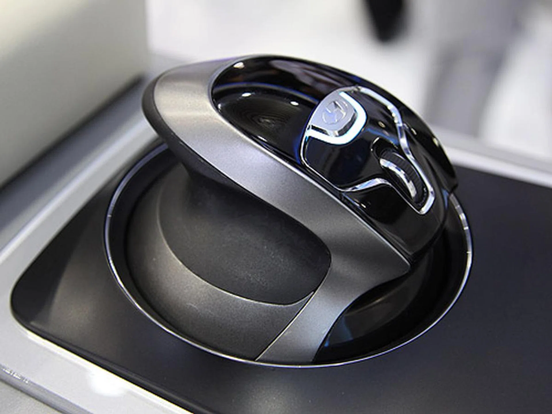 This futuristic looking mouse-like controller lets you select and navigate through the various controls including music and radio. It has an optical sensor above that translates gestures into navigation. 