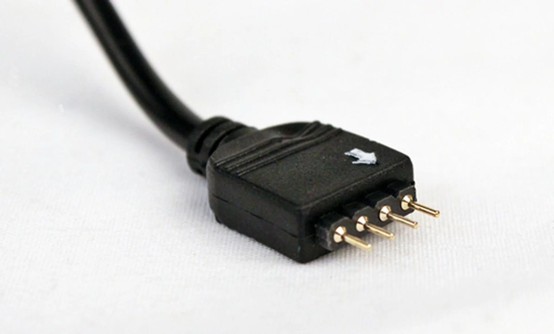 This is the four-pin plug that connects to the sleeved LED that regulates its power and color. Note the white arrow denoting the positive terminal.
