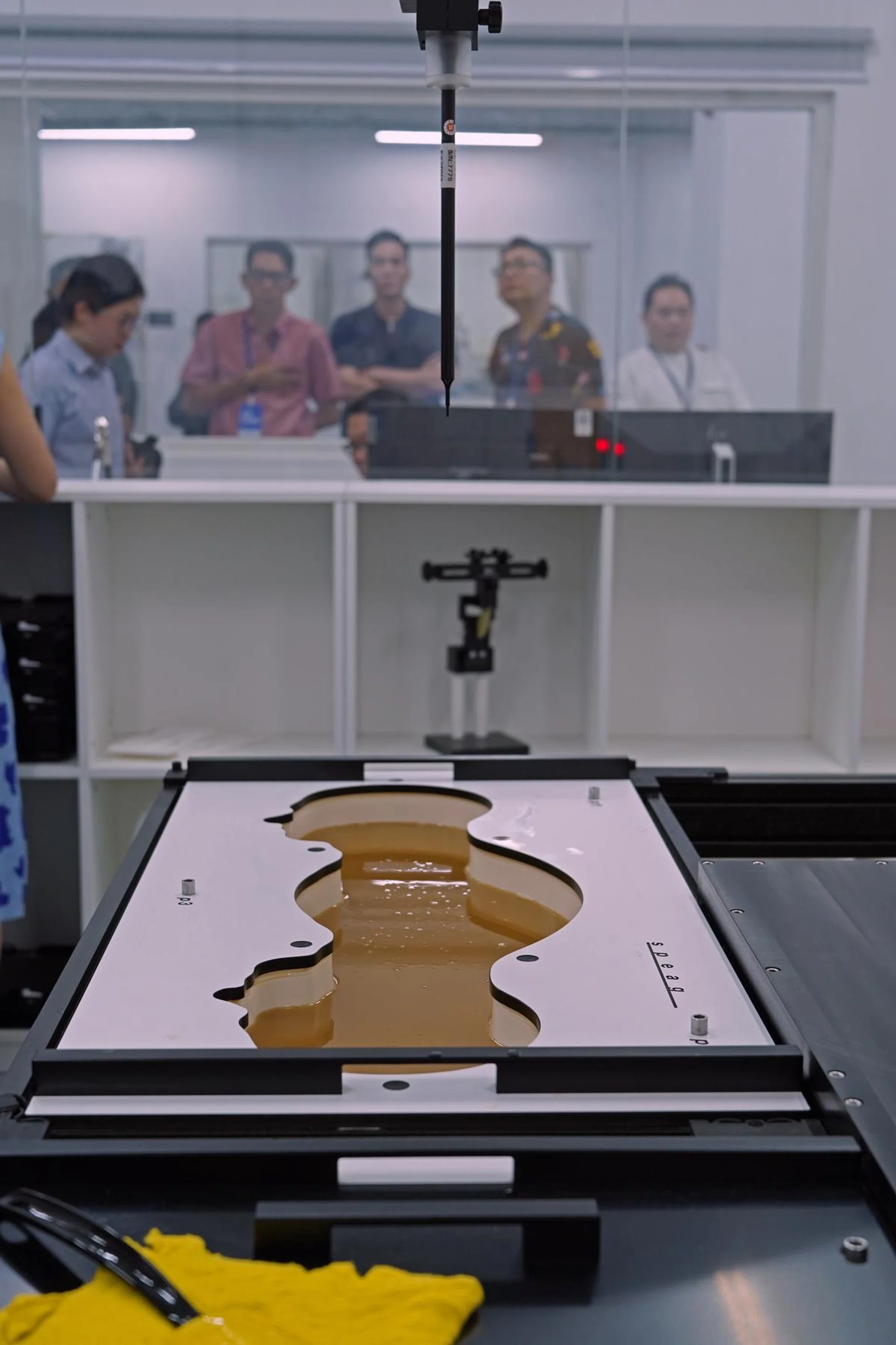 This test checks for radiation emitted from smartphones when it passes through a viscous mixture that resembles human tissue. The reading pole suspended above is inserted to give a reading. Image: Honor.