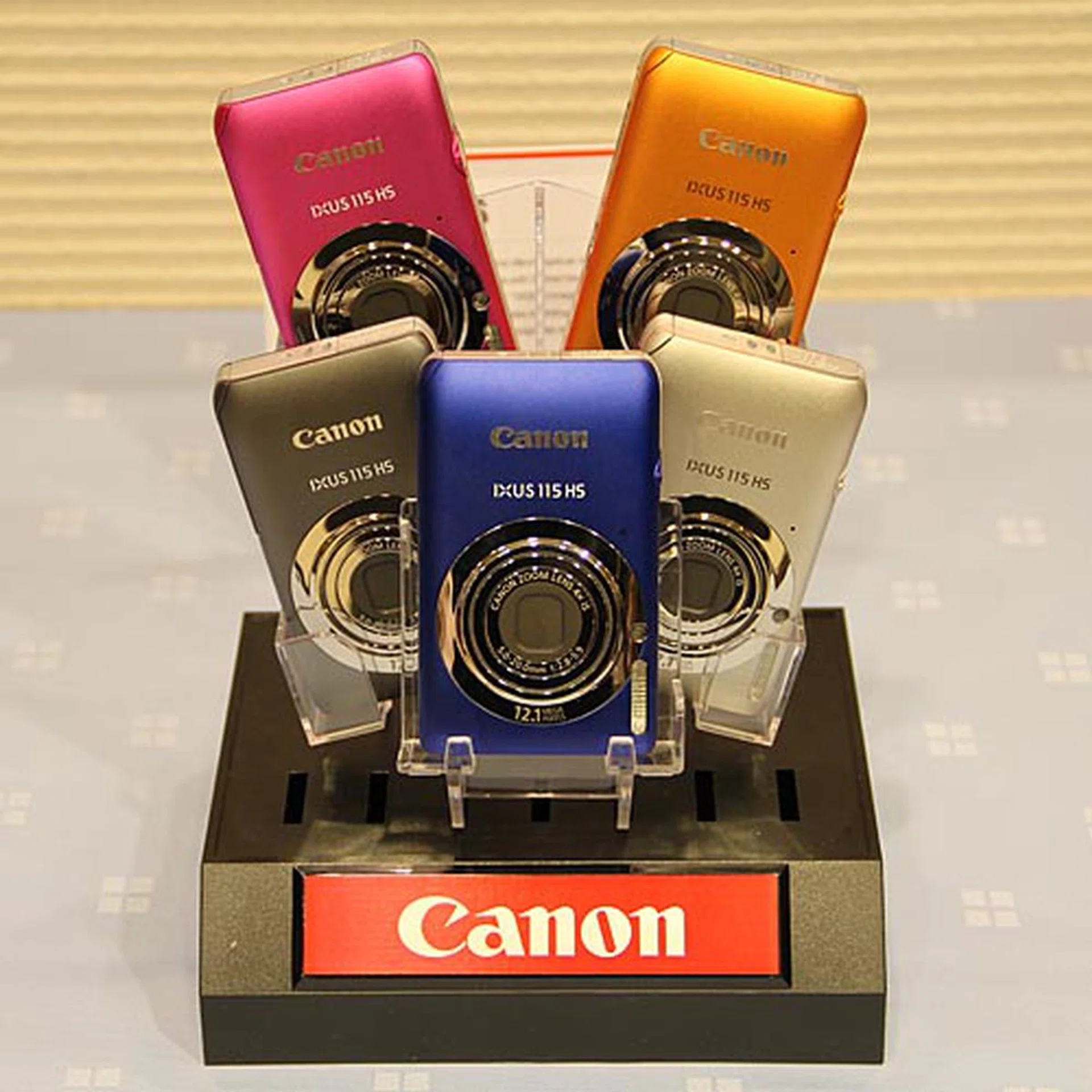 The 12.1-megapixel, Full HD movie recording-capable IXUS 115 HS has a 28 mm lens with 4x optical zoom, 3.0-inch LCD, and features Canon’s HS system. Other features include six creative filters, a Smart Auto mode that detects 32 different scenes, and the new Movie Digest feature. It’s available in orange, pink, blue, silver, and gray.