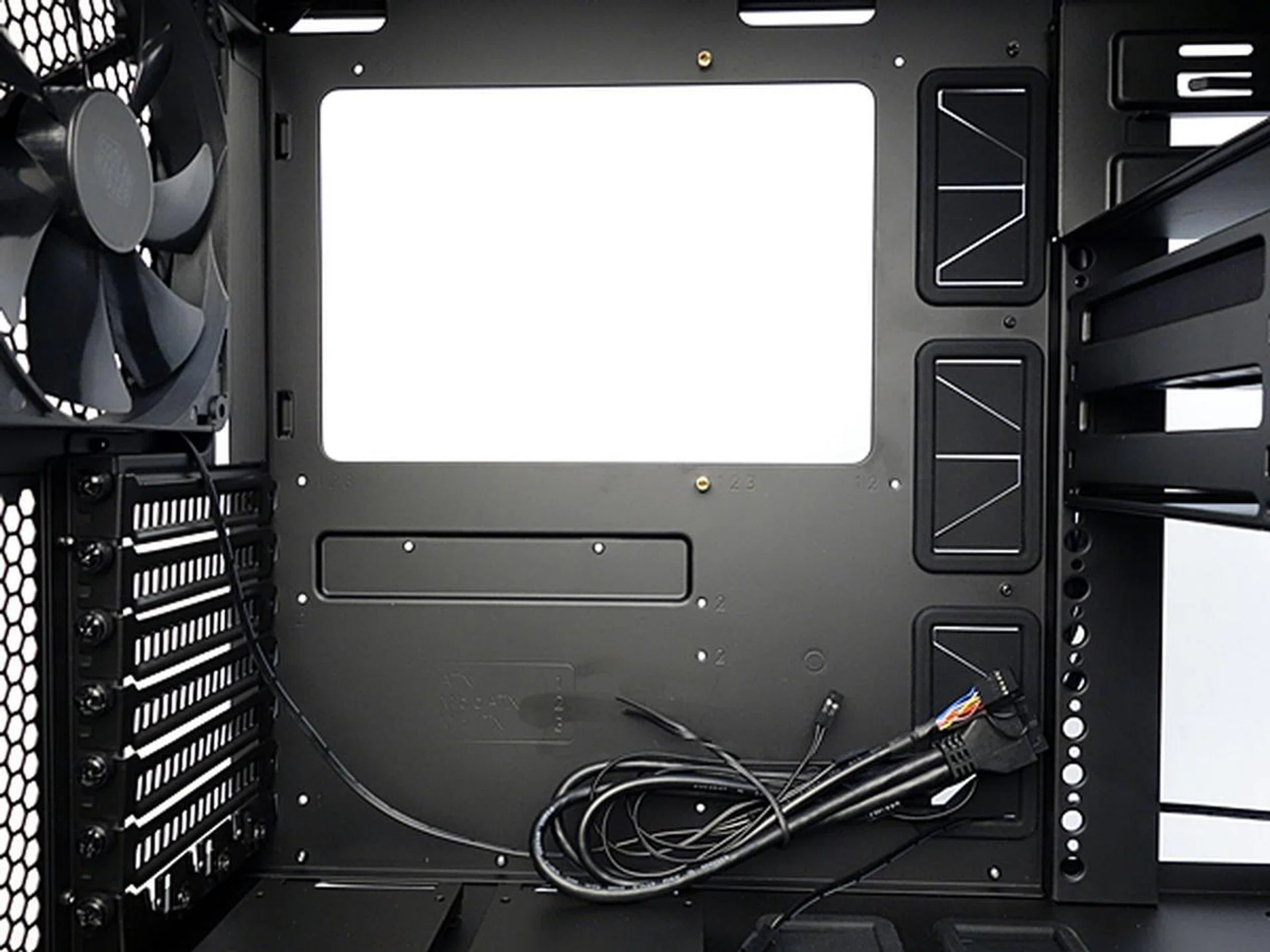 There's a large cut-out at the motherboard installation area. Noticed the rubber grommets to its right?