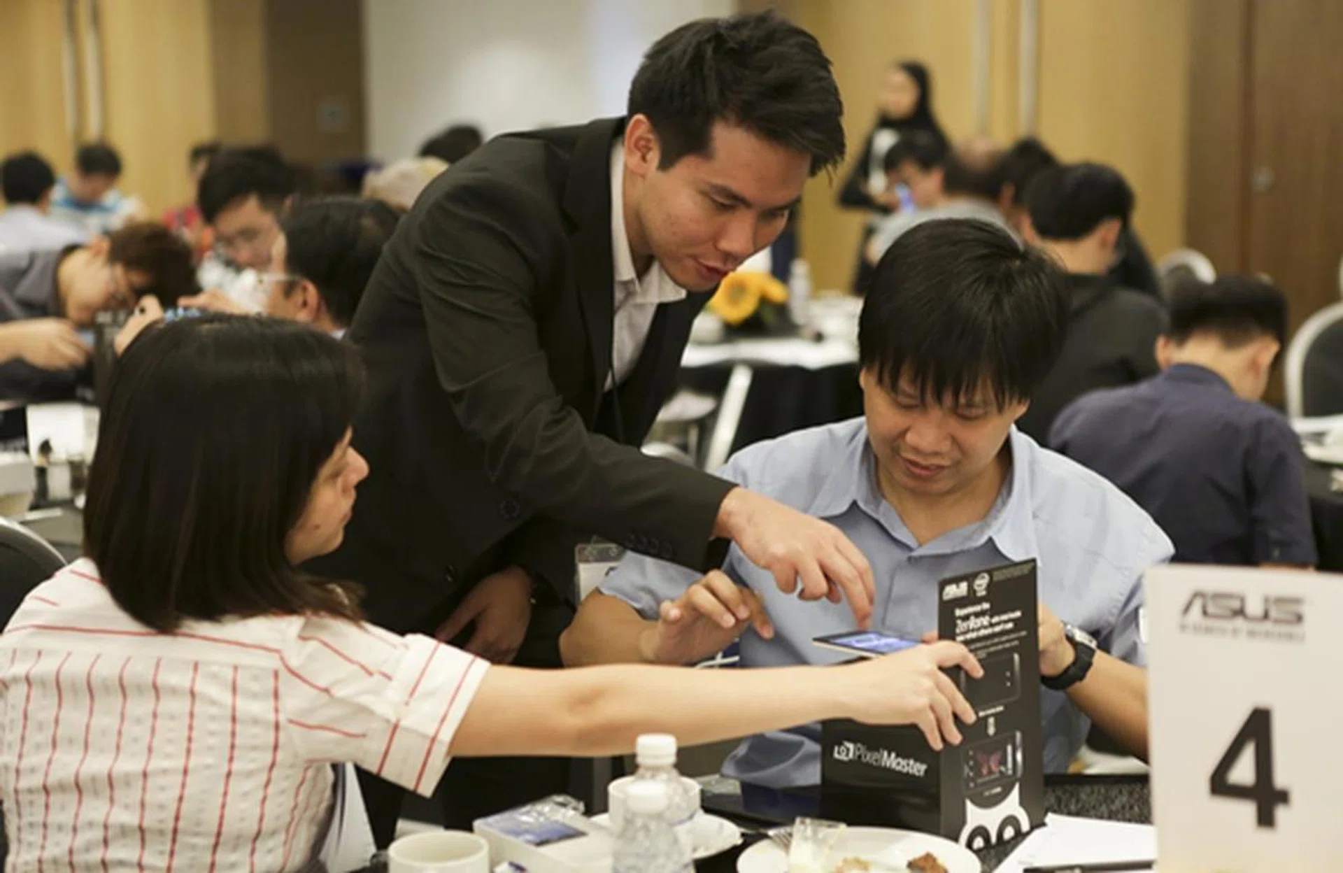 Derek guiding two participants how to use the Low Light mode of the ASUS ZenFone 5 LTE.